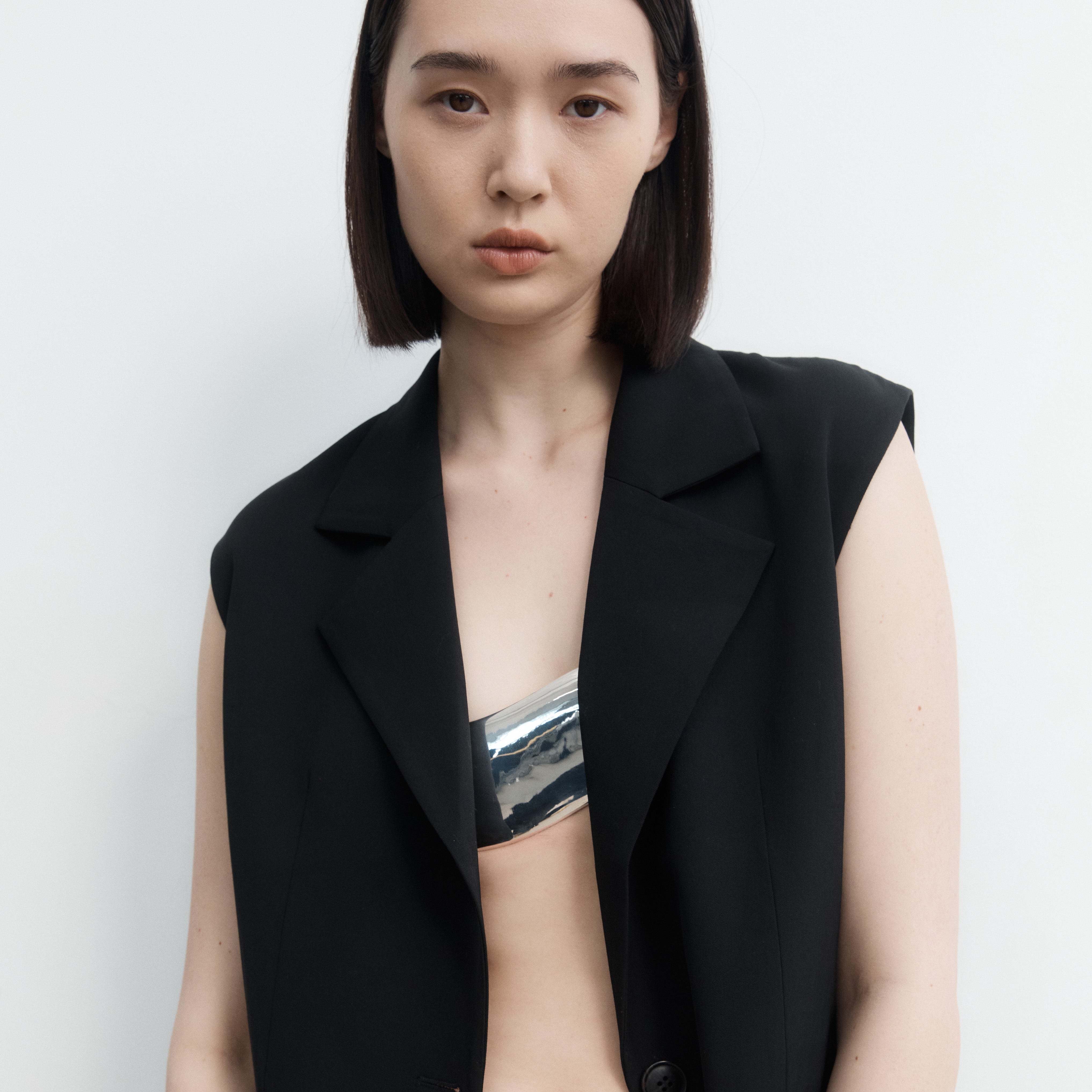 AGMES Sterling silver plated white bronze bra top with a black leather belt closure. St. Agni x AGMES Metal Bra Top Collaboration.