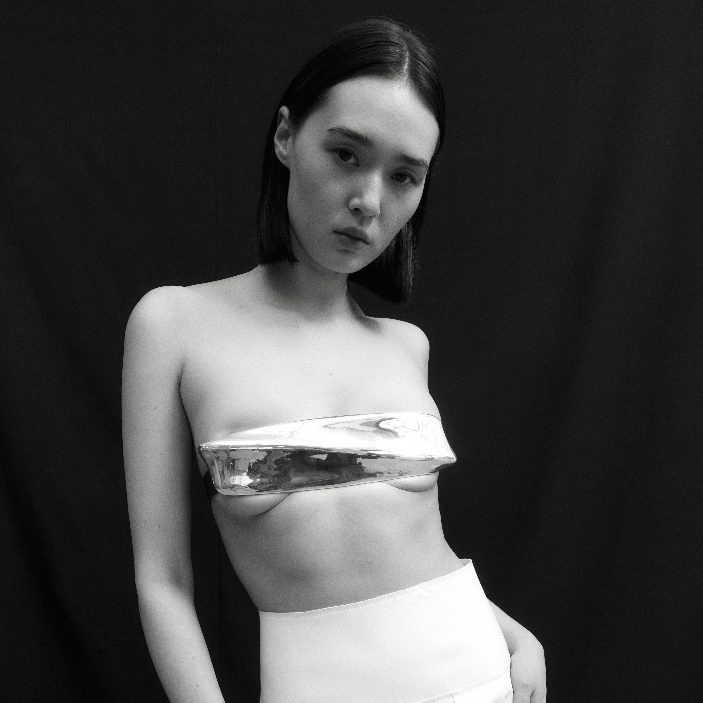 AGMES Sterling silver plated white bronze bra top with a black leather belt closure. St. Agni x AGMES Metal Bra Top Collaboration.
