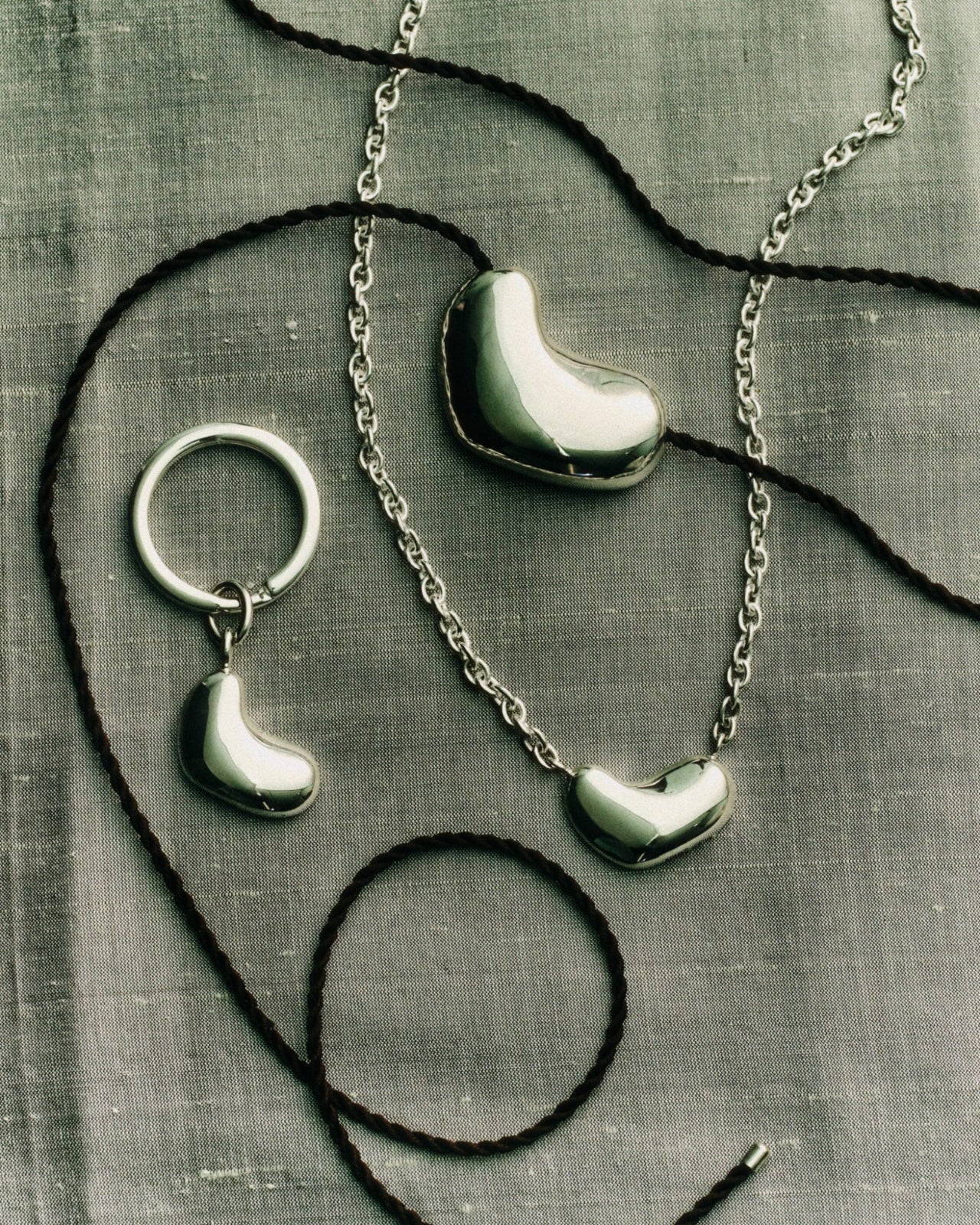AGMES .925 Sterling Silver Small Sculpted Heart Pendant II, Sculpted Heart Pendant on black suede, and Sculpted Heart Key Chain.