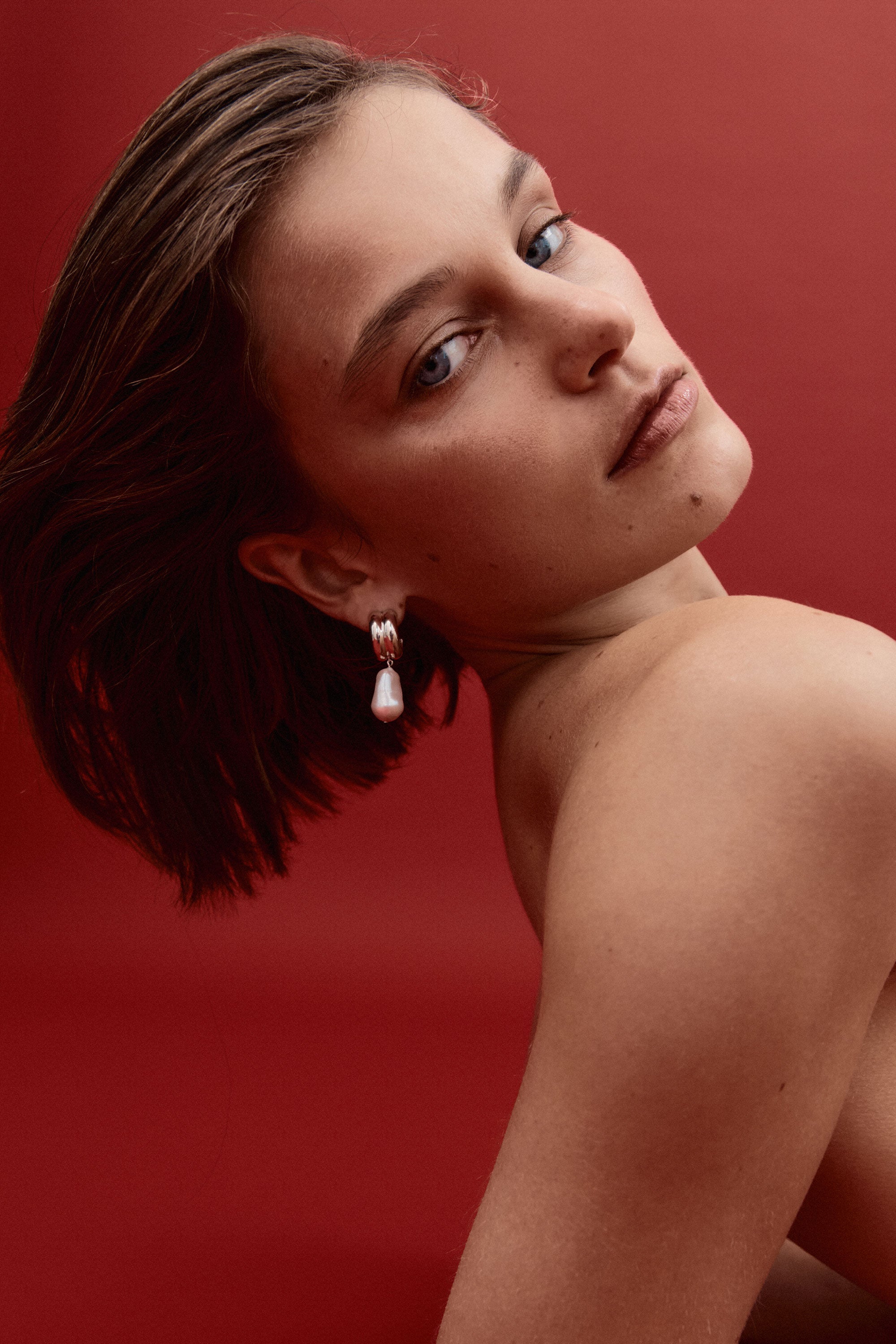 Woman wearing AGMES 0.925 sterling silver baroque Juliette earrings with freshwater pearl drop.