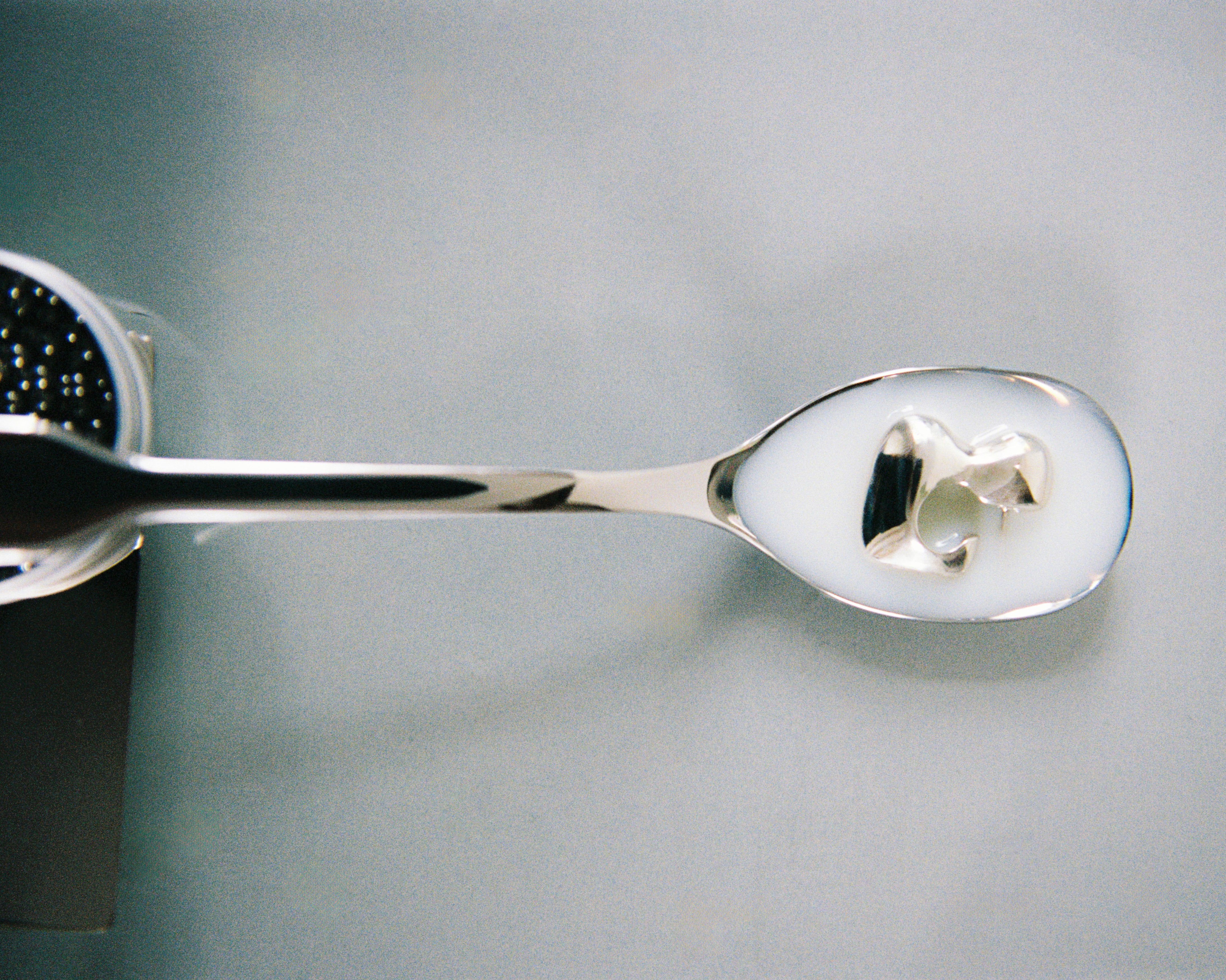 AGMES 0.925 sterling silver sculpted bubble hoop earrings submerged in white liquid. Simone Bodmer-Turner.