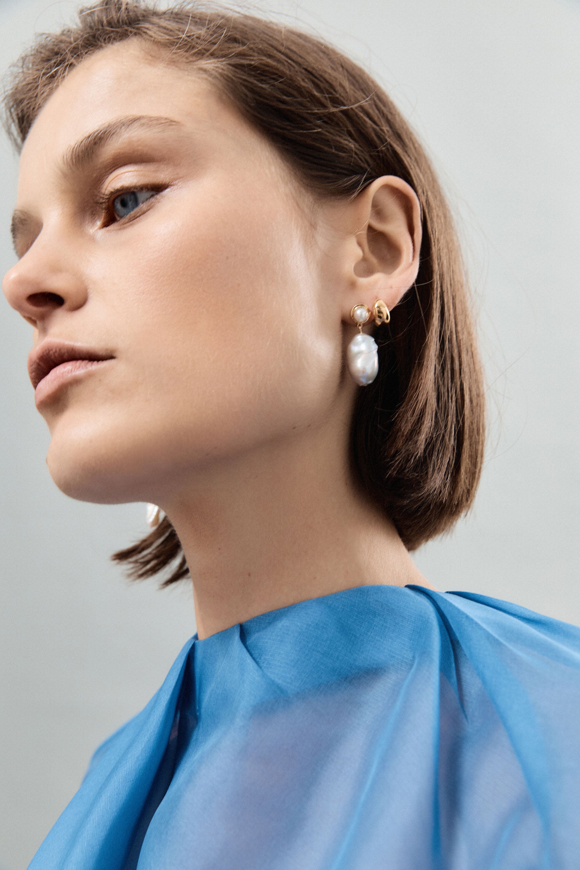 Woman wearing AGMES yellow gold vermeil Delphine earrings with freshwater pearl.