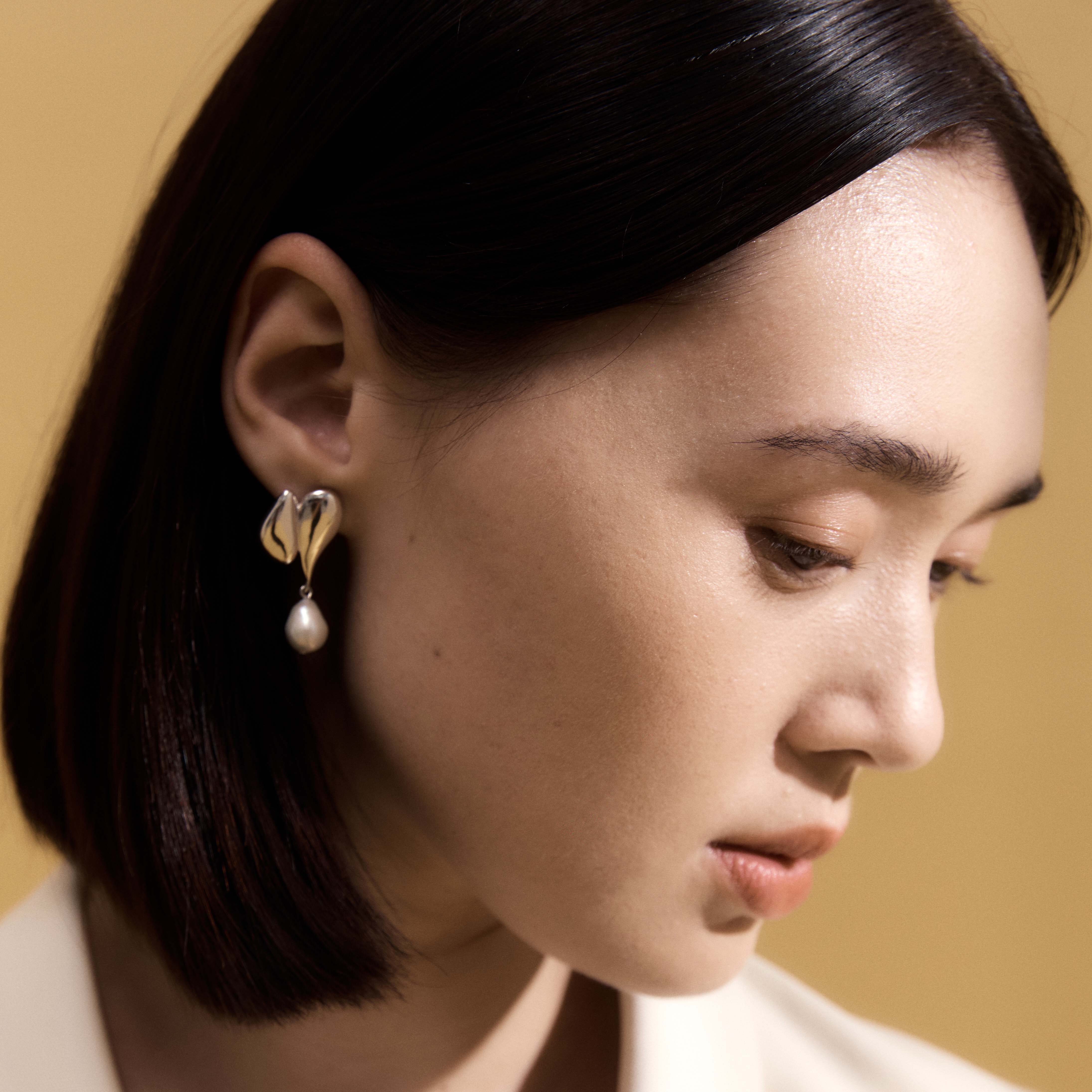 Woman wearing AGMES 0.925 sterling silver drop pearl Elvira earrings.