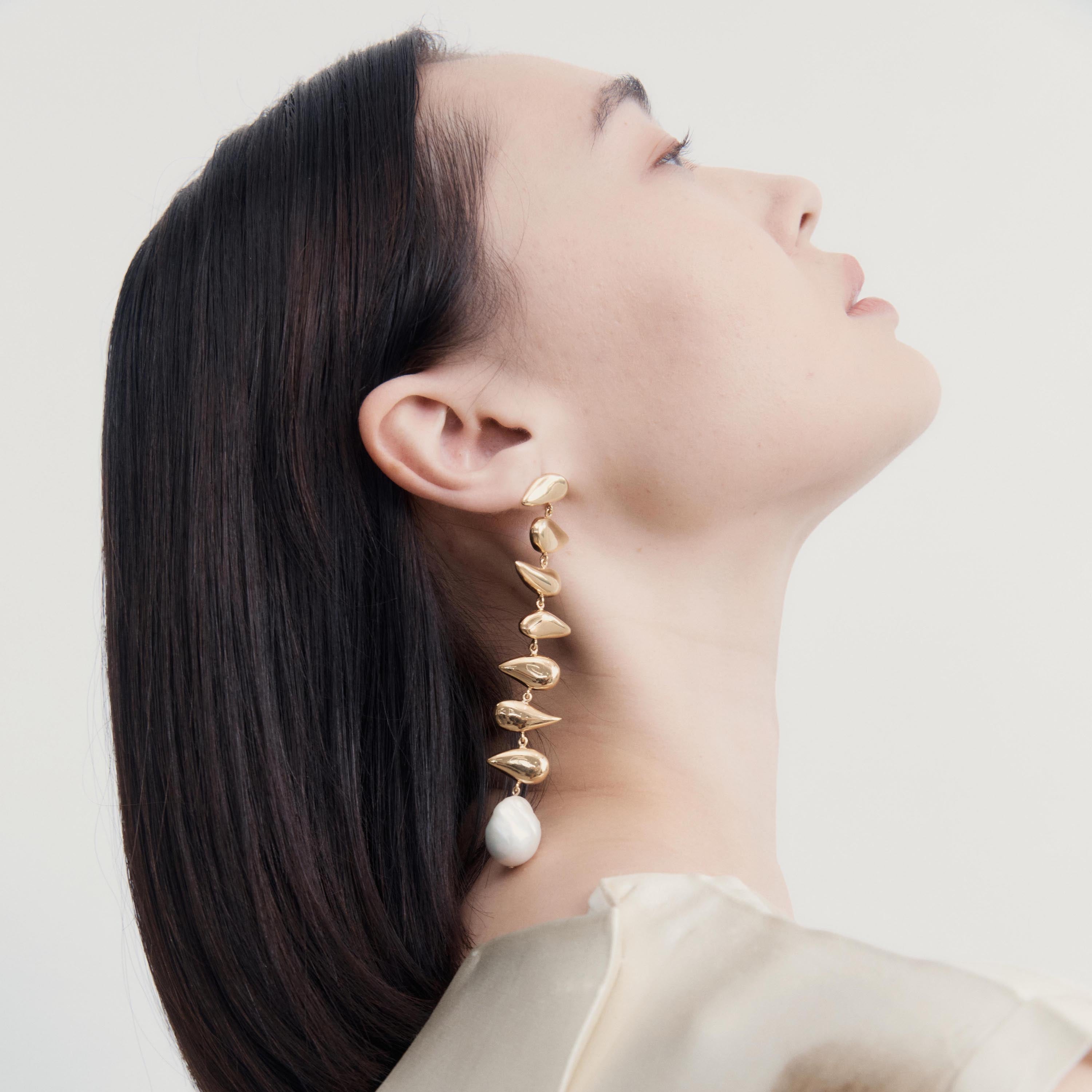 Woman wearing AGMES 18k yellow gold vermeil long drop freshwater pearl Florence earrings.