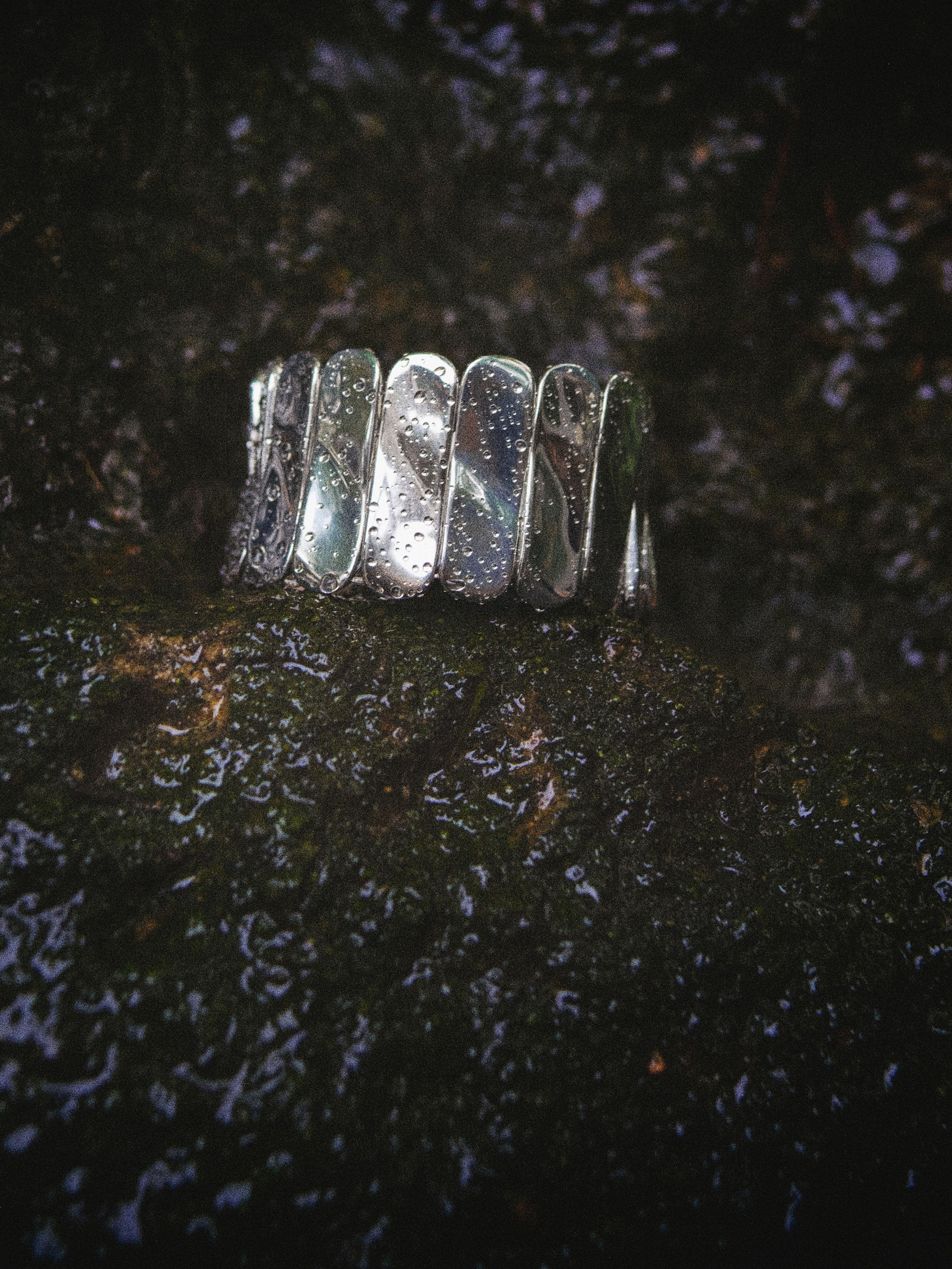 AGMES 0.925 sterling silver Ilona Bracelet with adjustable elastic band on moss covered rock.