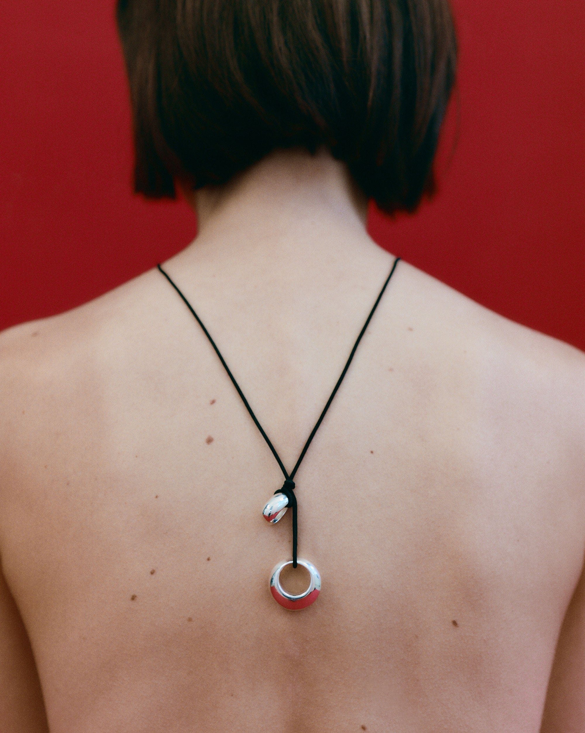 Person wearing AGMES 0.925 Sterling Silver Rae Pendant with Black Suede Cord on back.