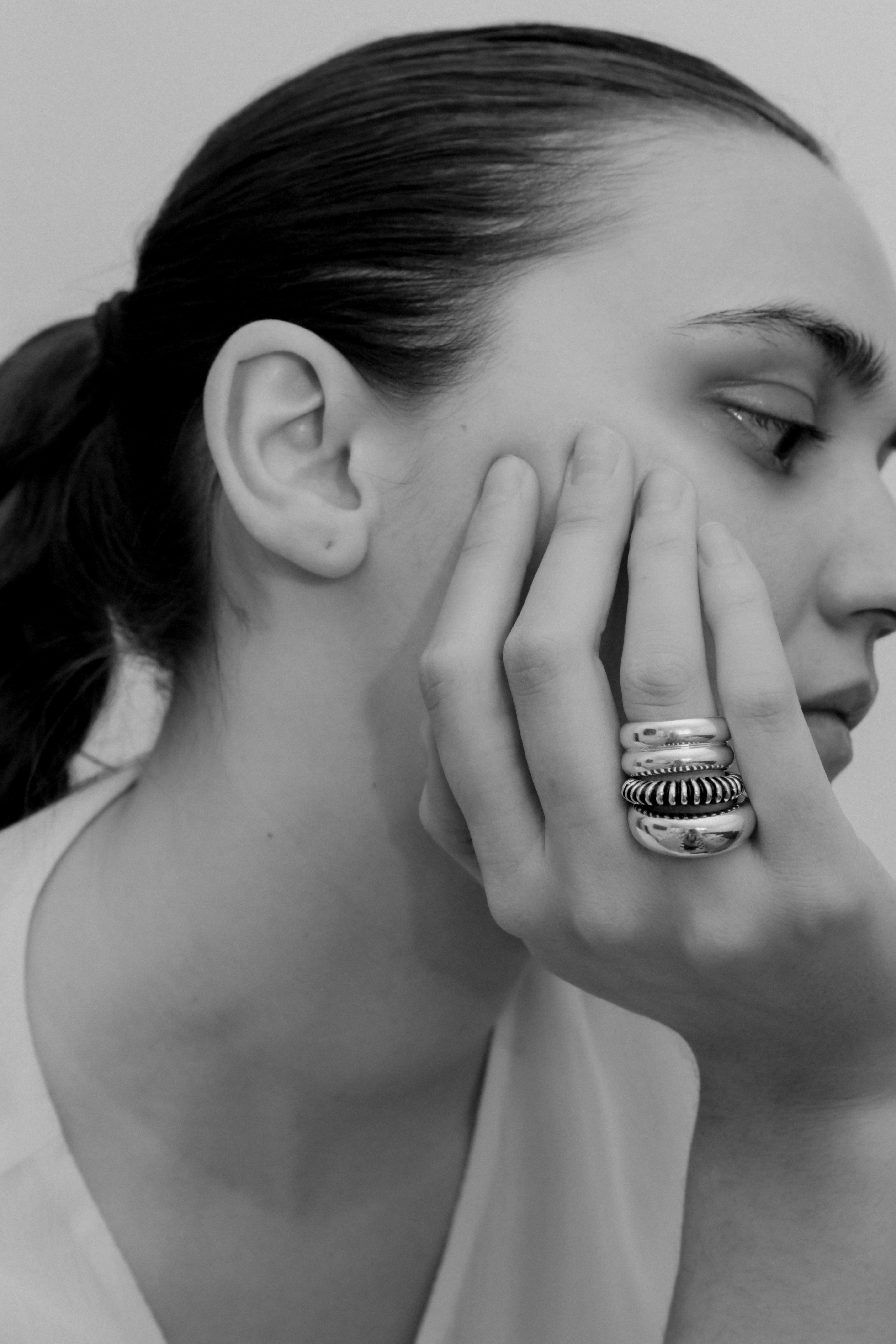 Woman wearing the AGMES .925 Sterling Silver Bertrand Ring, Ridge Ring, and Domed Ring.