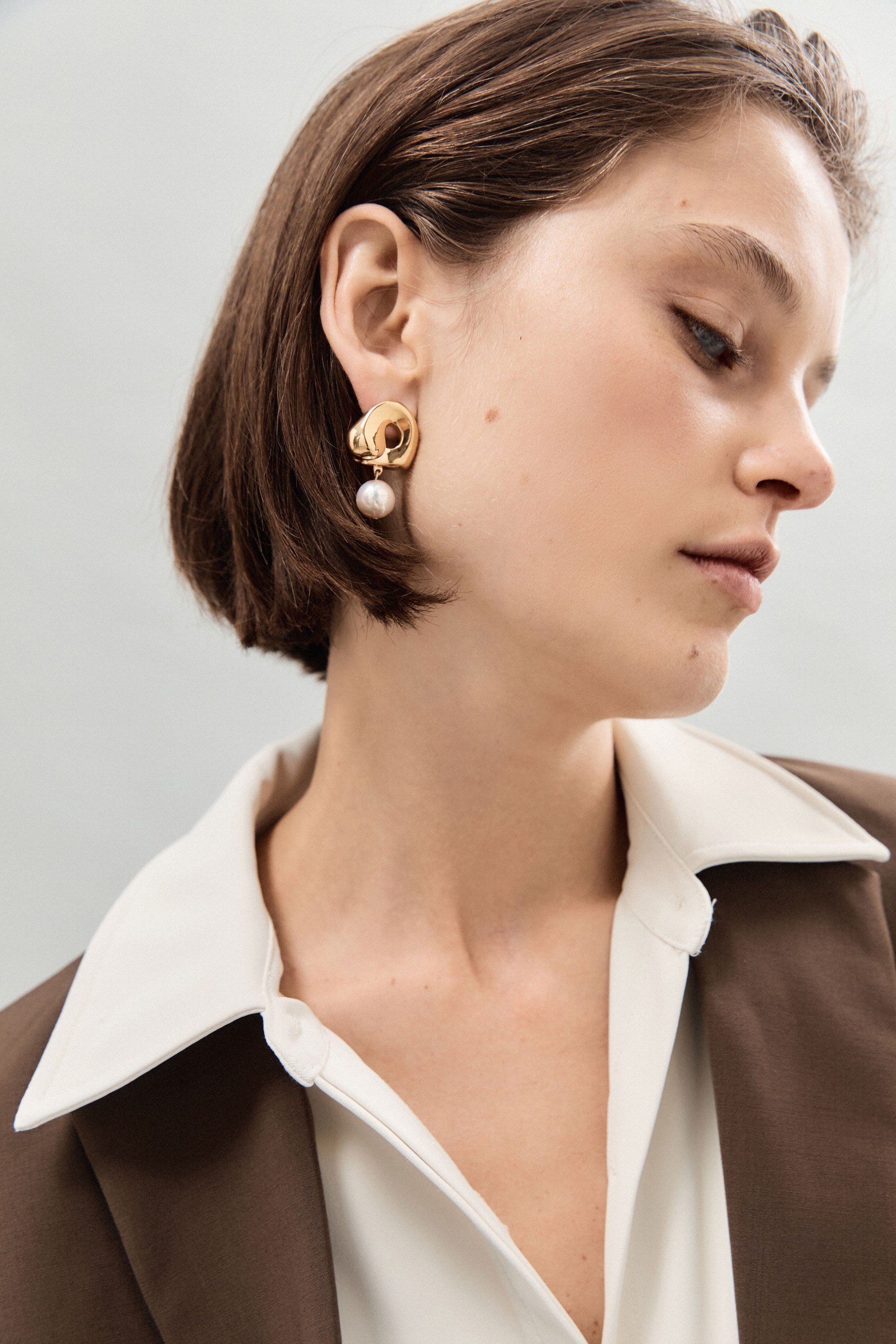 Woman wearing AGMES 18k gold vermeil sculpted Gertrude pearl drop earrings. Simone Bodmer-Turner.