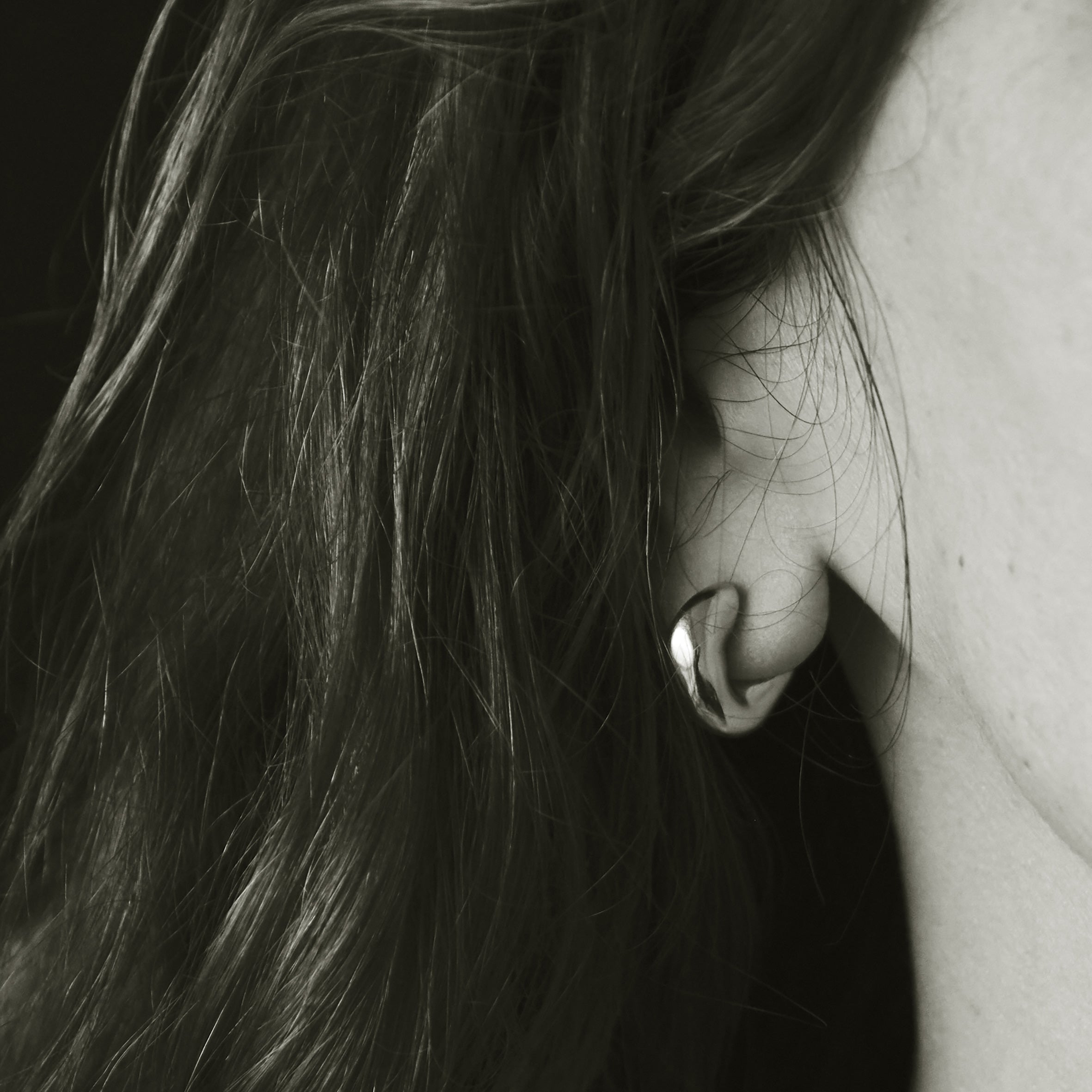 Woman wearing AGMES 18k gold vermeil thick hoop earrings.