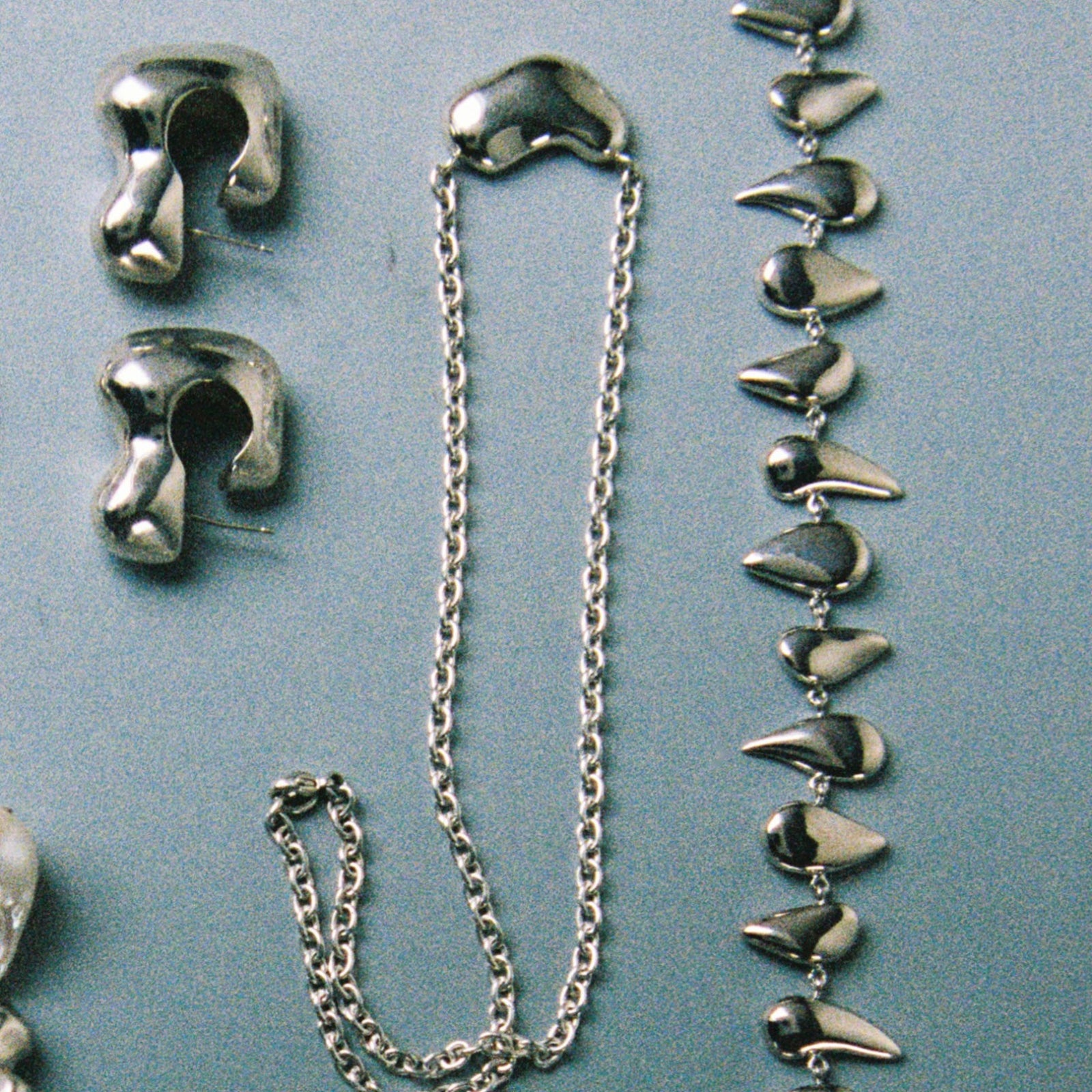 AGMES .925 Sterling Silver Small Sculpted Heart Pendant II on chain necklace. Displayed alongside Flora necklace and Bubble Hoops.