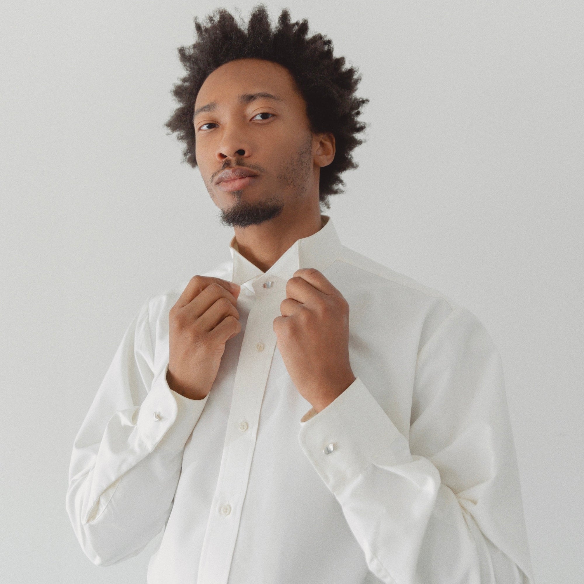 Man wearing the AGMES .925 Sterling Silver Sum of Parts Mini Brooch on white shirt.