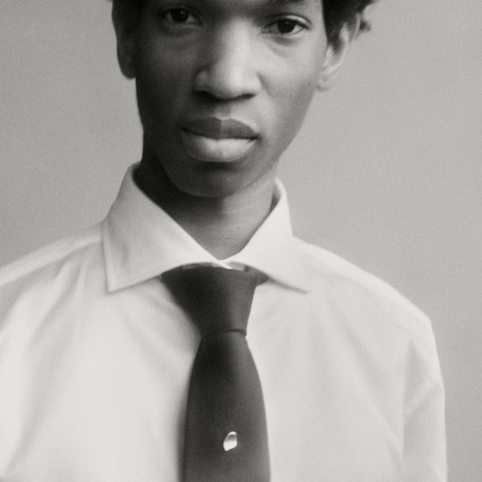 Model wearing AGMES .925 sterling silver Sum of Parts heart Tie Tack on black tie.