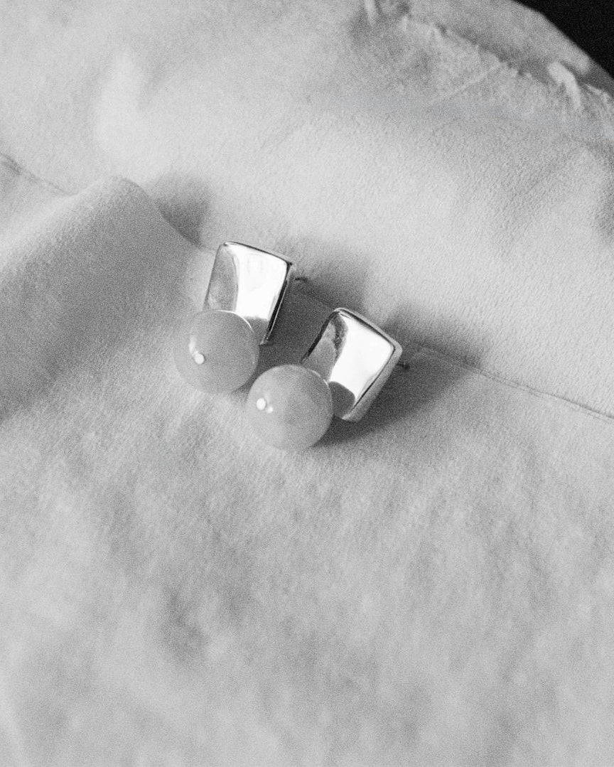 AGMES.925 sterling silver and rose quartz Luca Earrings. Photographed in black and white sitting on a pieces of white fabric.
