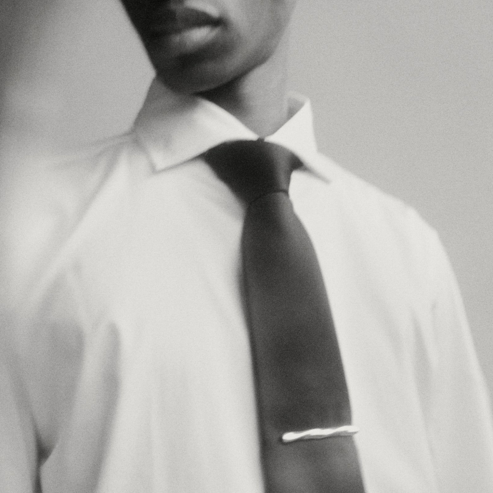 Model wearing AGMES .925 sterling silver sculptural Astrid Tie Clip on black tie.
