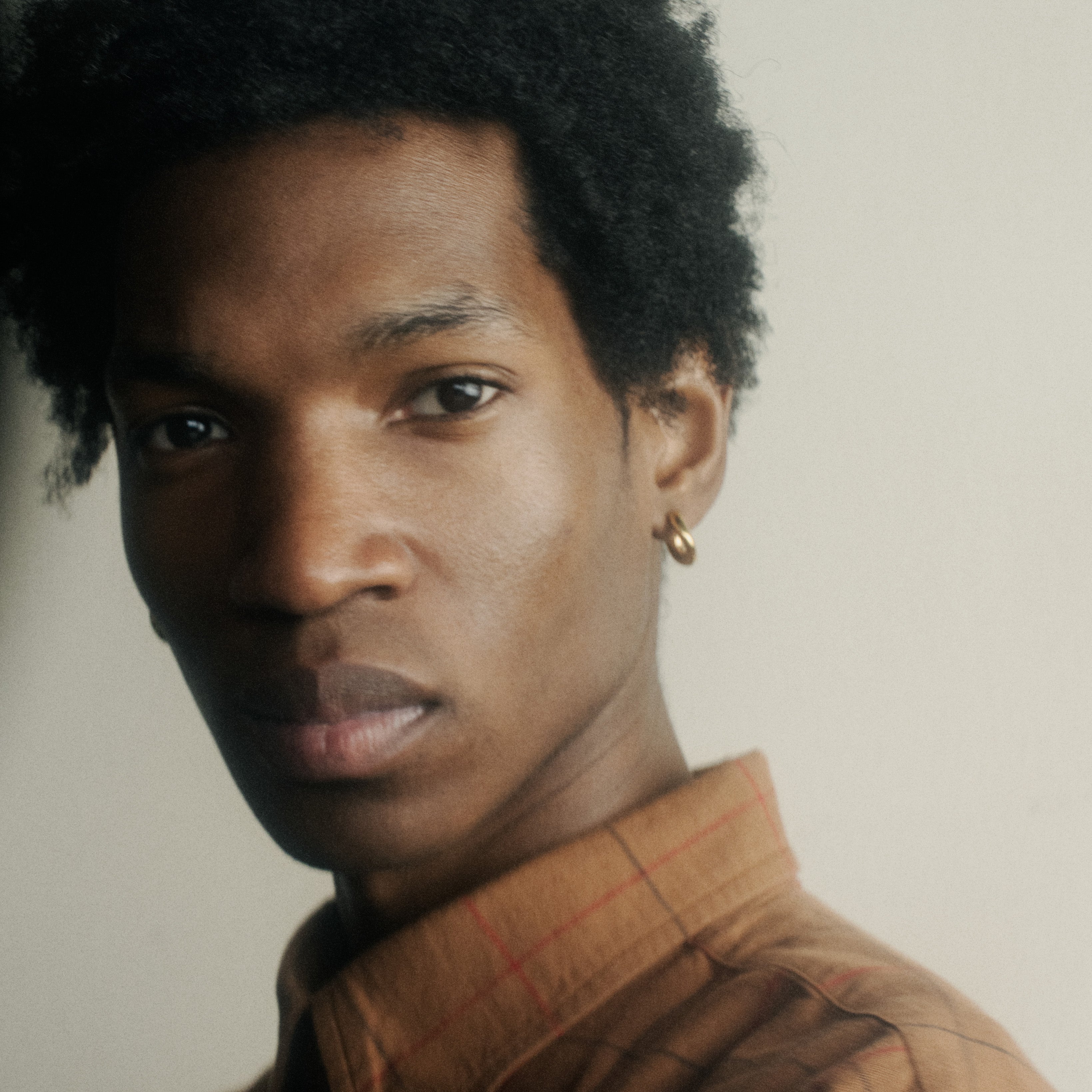 Person wearing AGMES 18k gold vermeil mini hoop earrings.