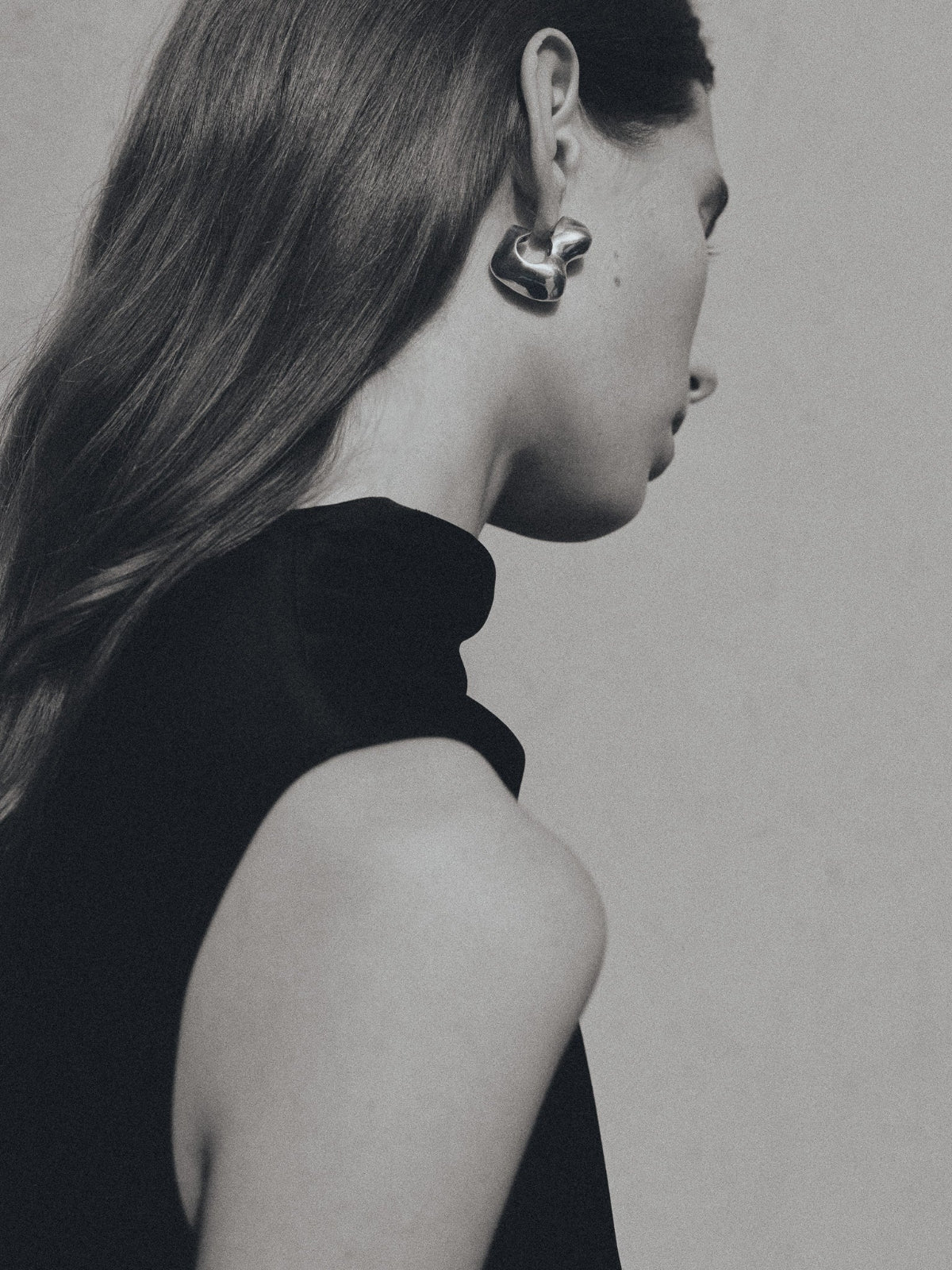Woman wearing AGMES 0.925 sterling silver sculpted bubble hoop earrings. Simone Bodmer-Turner.