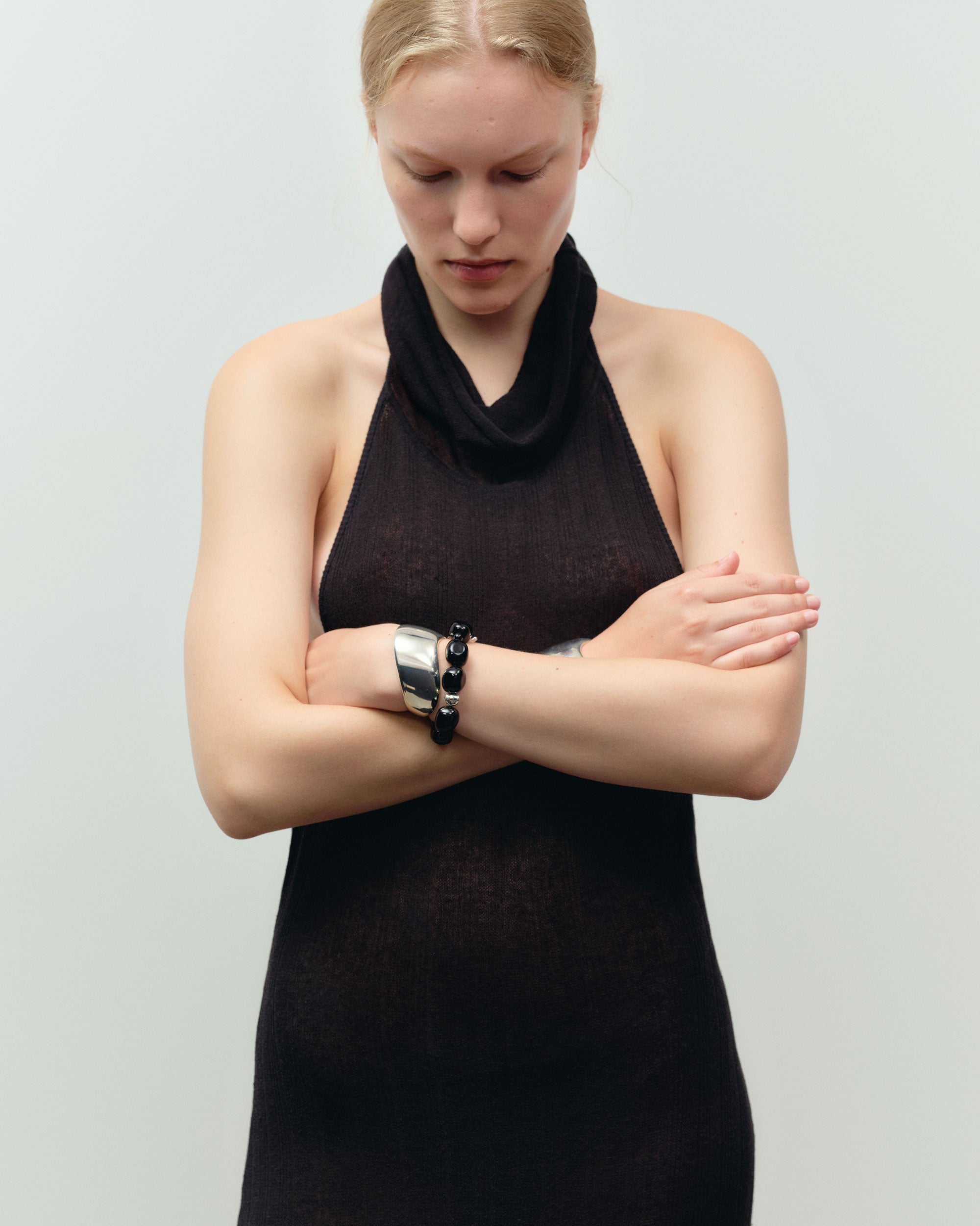 Black onyx beaded bracelet with .925 sterling silver accent layered on woman's wrist with Cecil cuff
