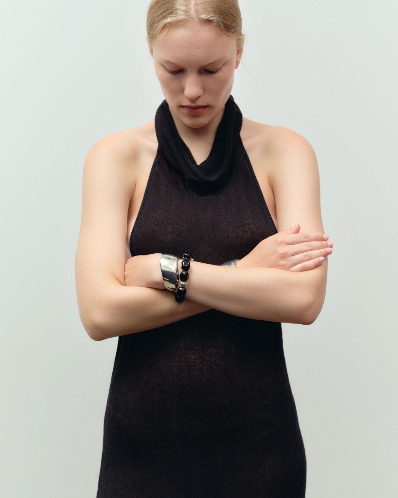 Black onyx beaded bracelet with .925 sterling silver accent layered on woman's wrist with Cecil cuff