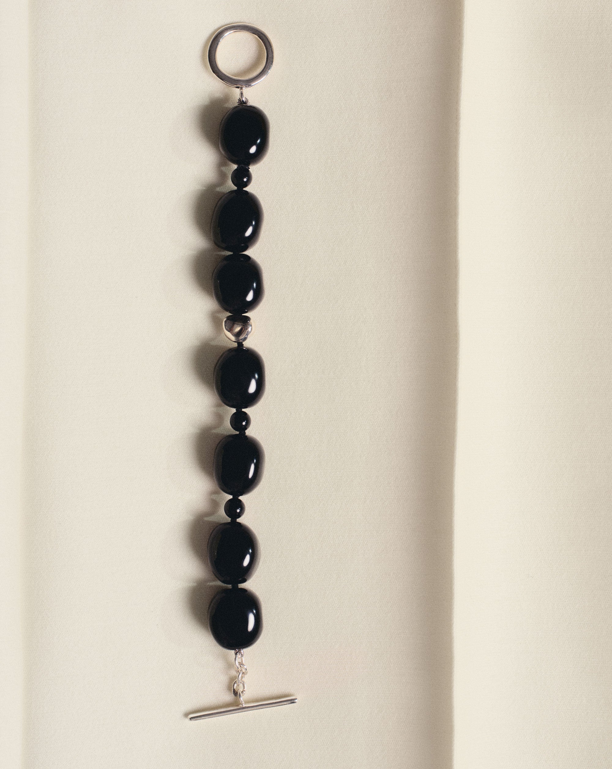 Black onyx beaded bracelet with .925 sterling silver accent on off-white background