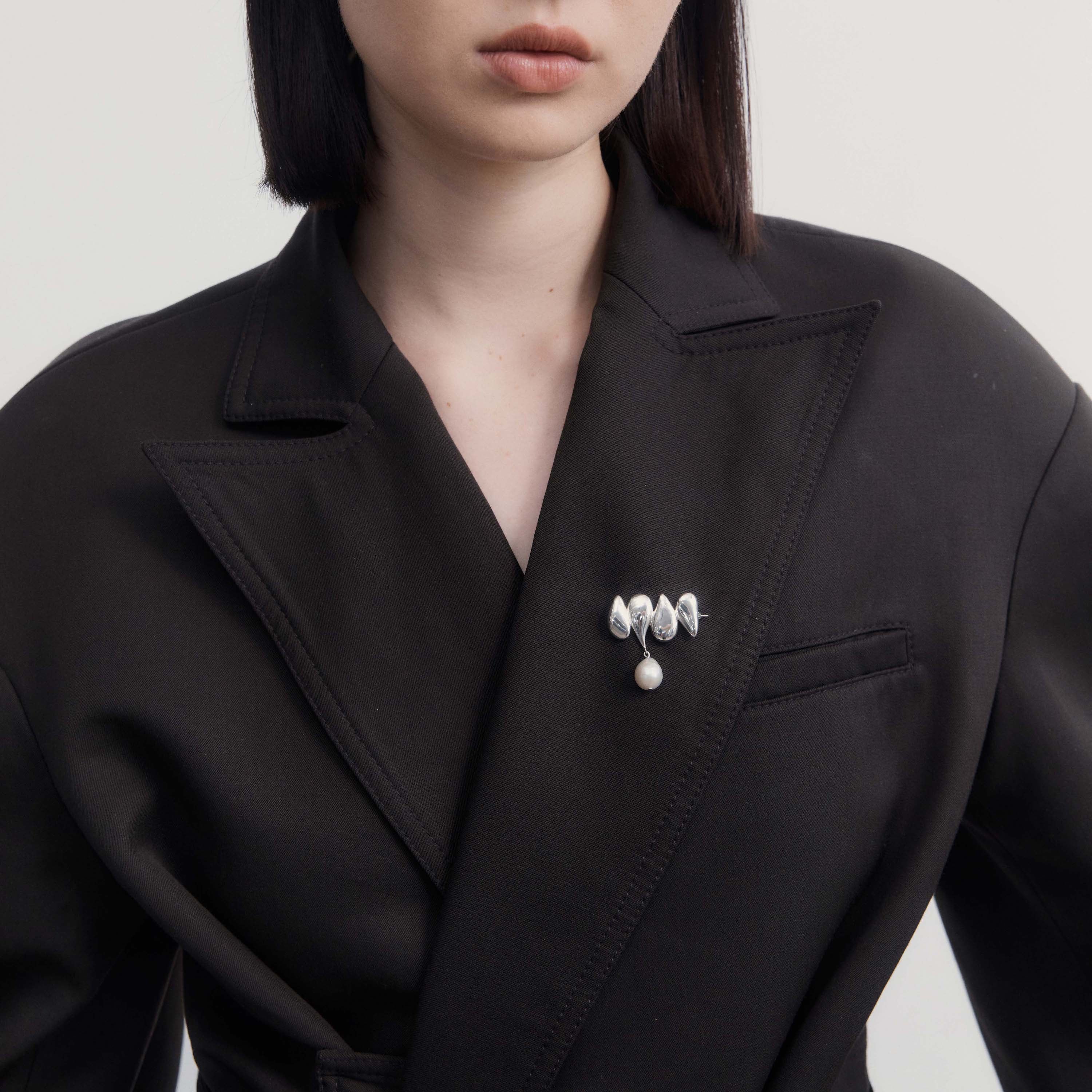 Person wearing AGMES .925 Sterling Silver Joy Brooch with Baroque Pearl Drop on black blazer.
