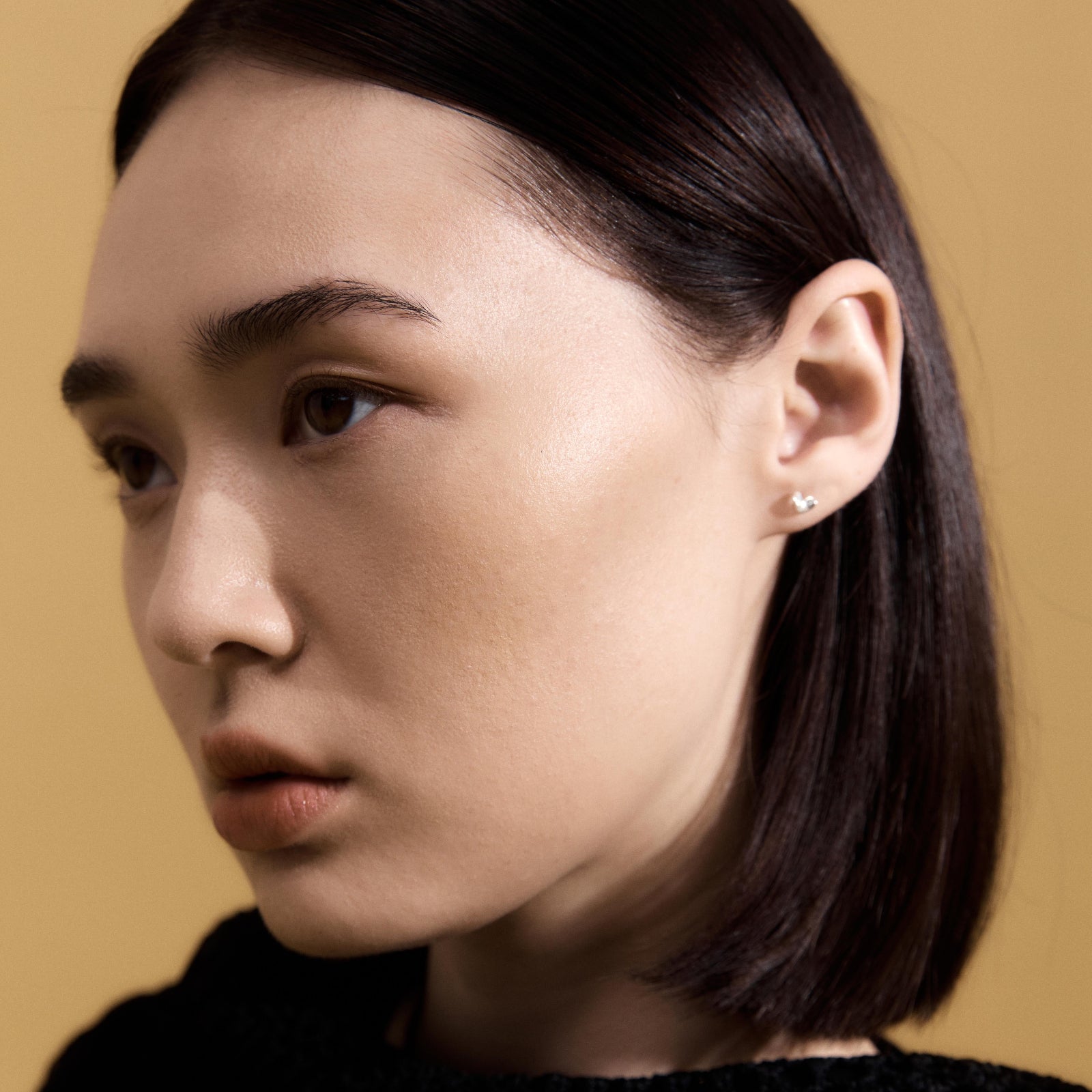 Woman wearing AGMES .925 Sterling Silver Mini Sculpted Heart Stud Earrings