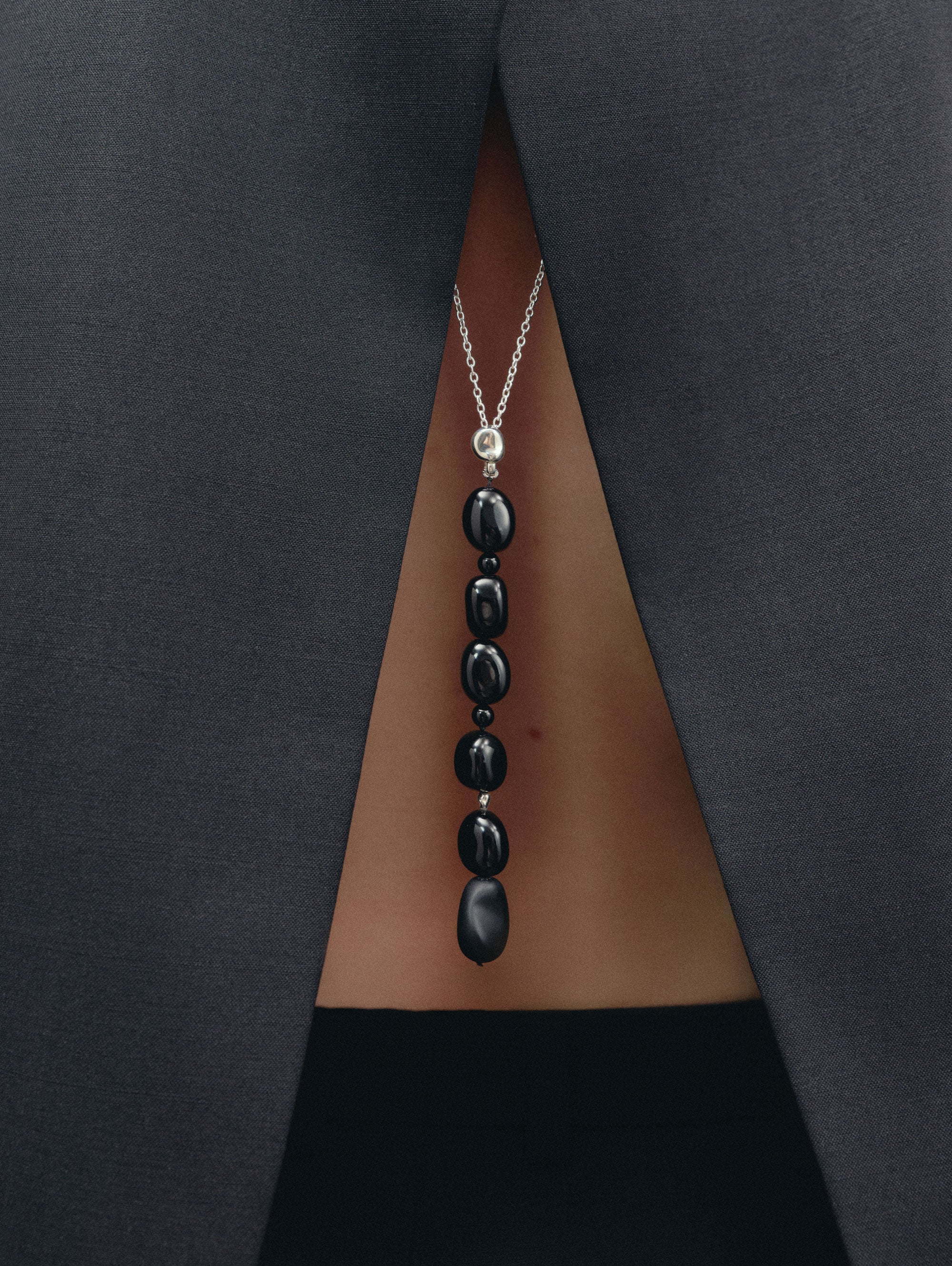Black Onyx beaded pendant drop necklace on sterling silver chain on woman's back
