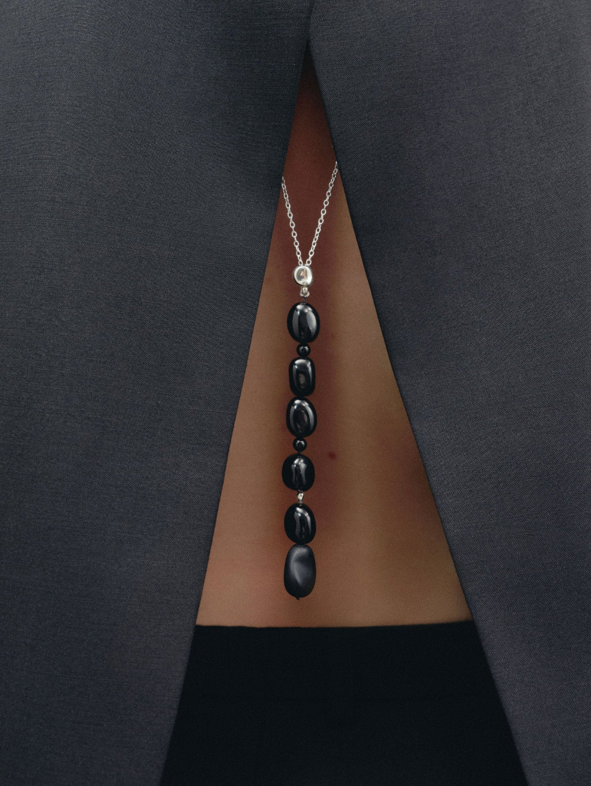 Black Onyx beaded pendant drop necklace on sterling silver chain on woman's back