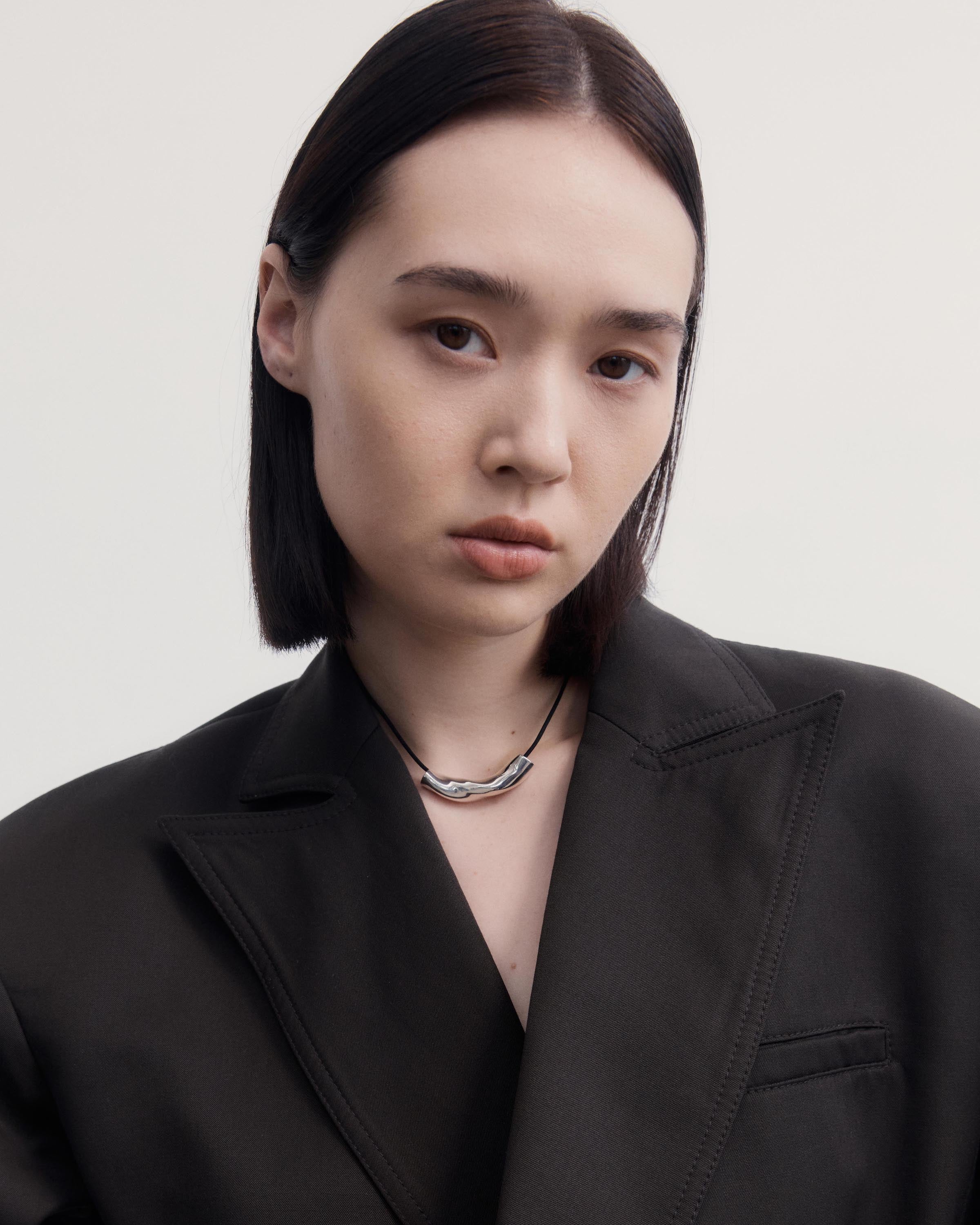 Woman wearing AGMES .925 Sterling Silver Small Astrid Pendant on Black Suede Cord.