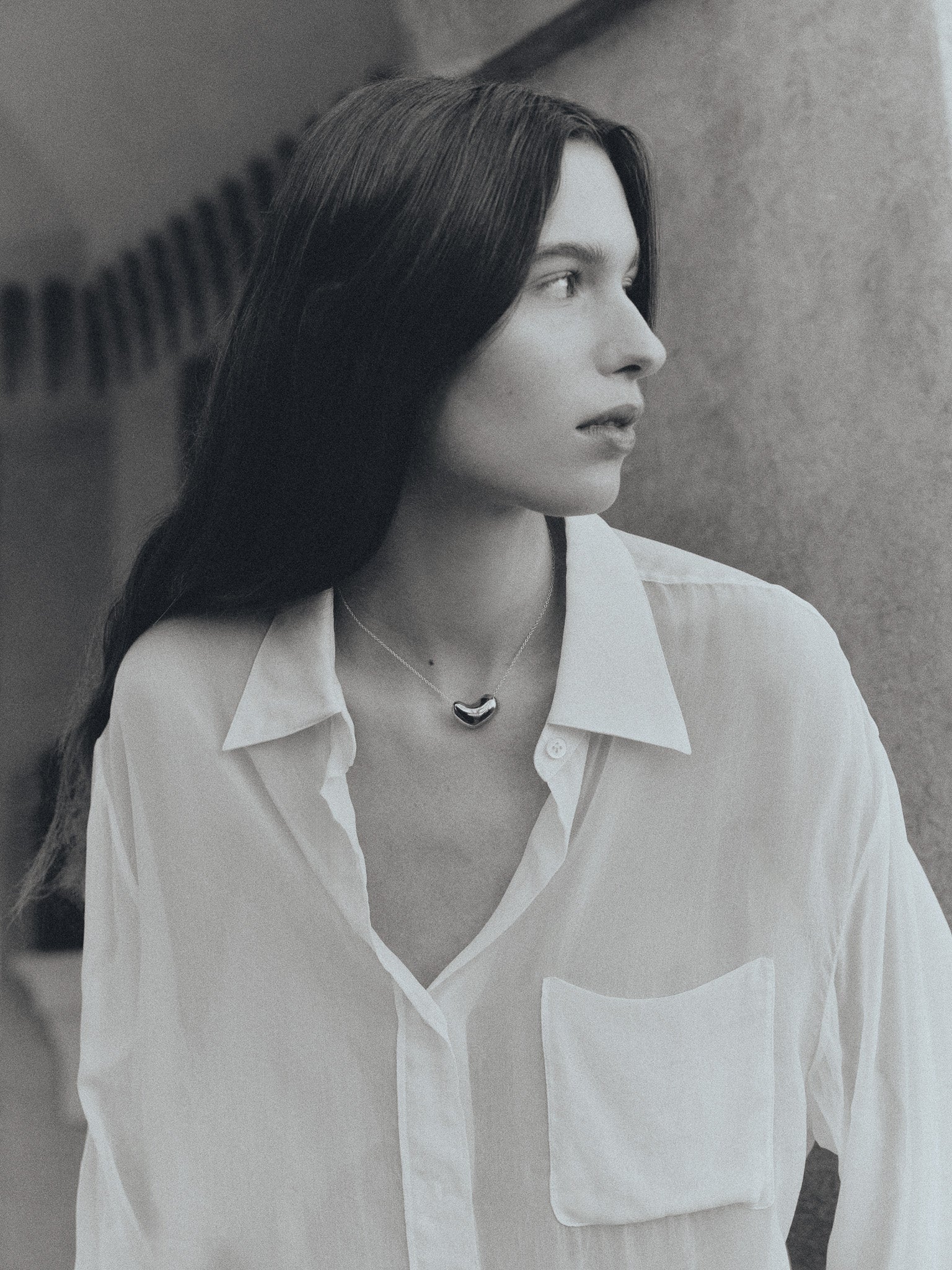 Woman wearing AGMES .925 Sterling Silver Small Sculpted Heart Pendant.