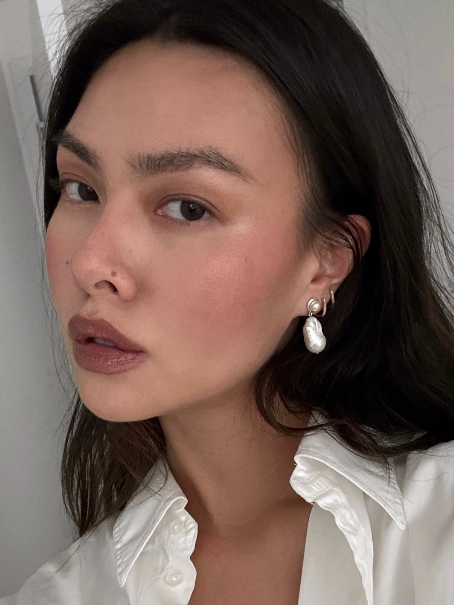 Woman wearing AGMES 0.925 sterling silver Delphine earrings with freshwater pearl.