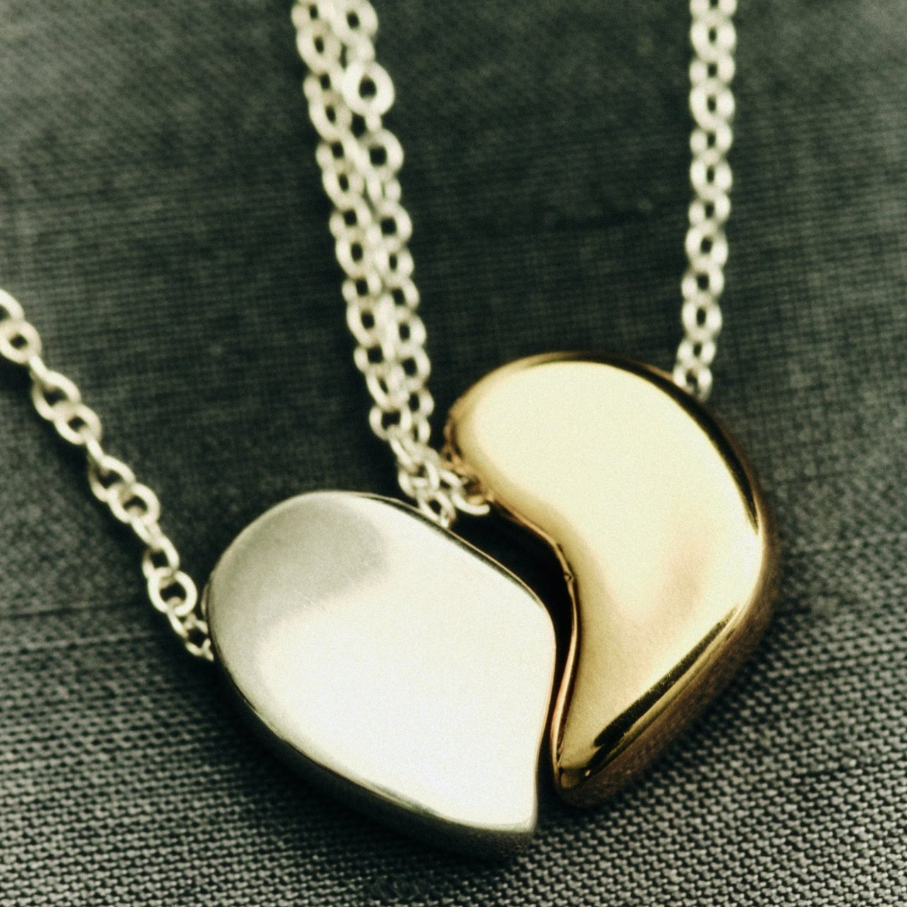AGMES .925 sterling silver and 18k gold vermeil sculptural heart Sum of Parts Pendant Set matching necklaces. on textured background.
