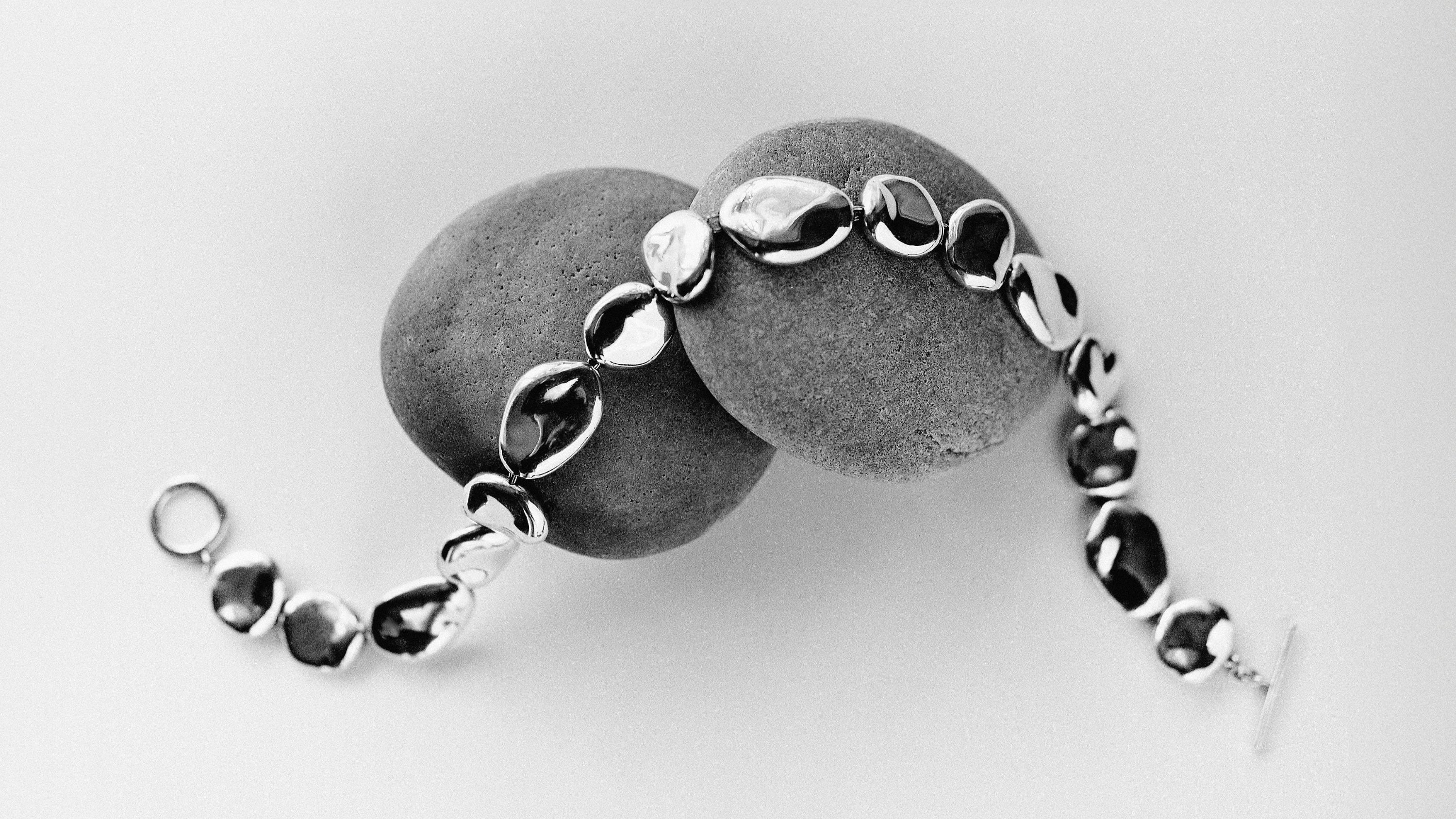 AGMES .925 sterling silver sculptural round organic collar Conie Necklace displayed on grey stones with white background.