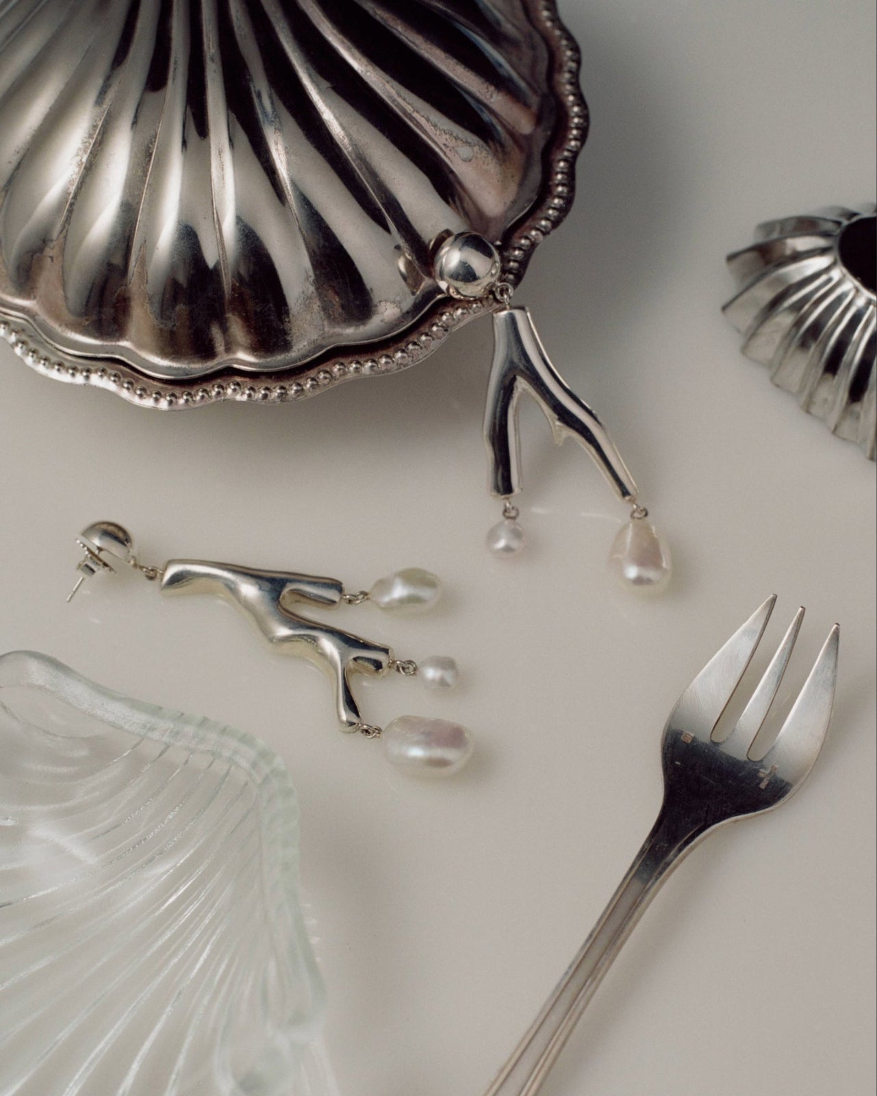 AGMES .925 sterling silver and freshwater pearl Baroque Coral Earrings still life image with silver fork and shell dish.