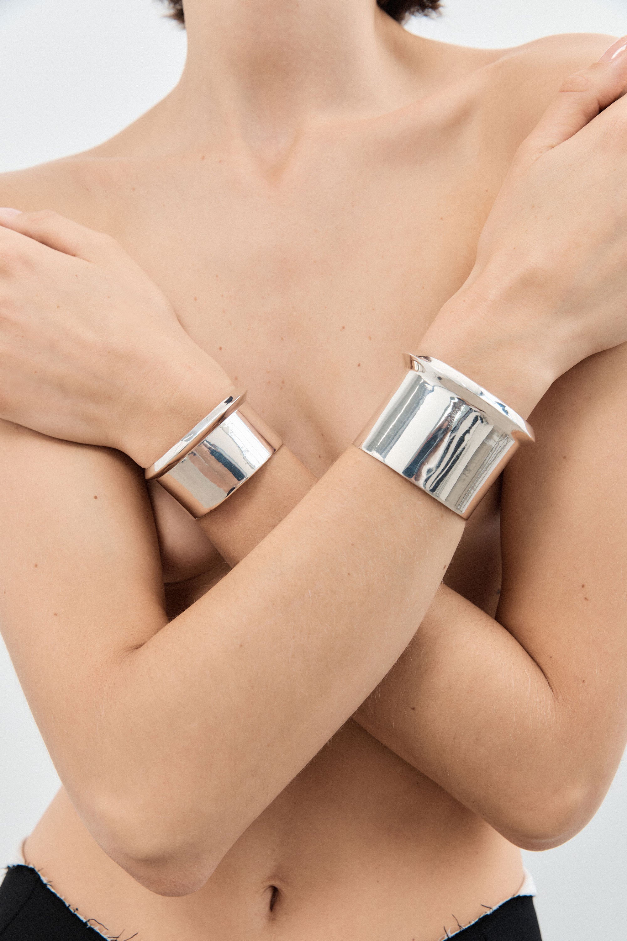 Woman wearing AGMES 0.925 sterling silver simple and modern cuff set with a geometric scallop detail on edges.