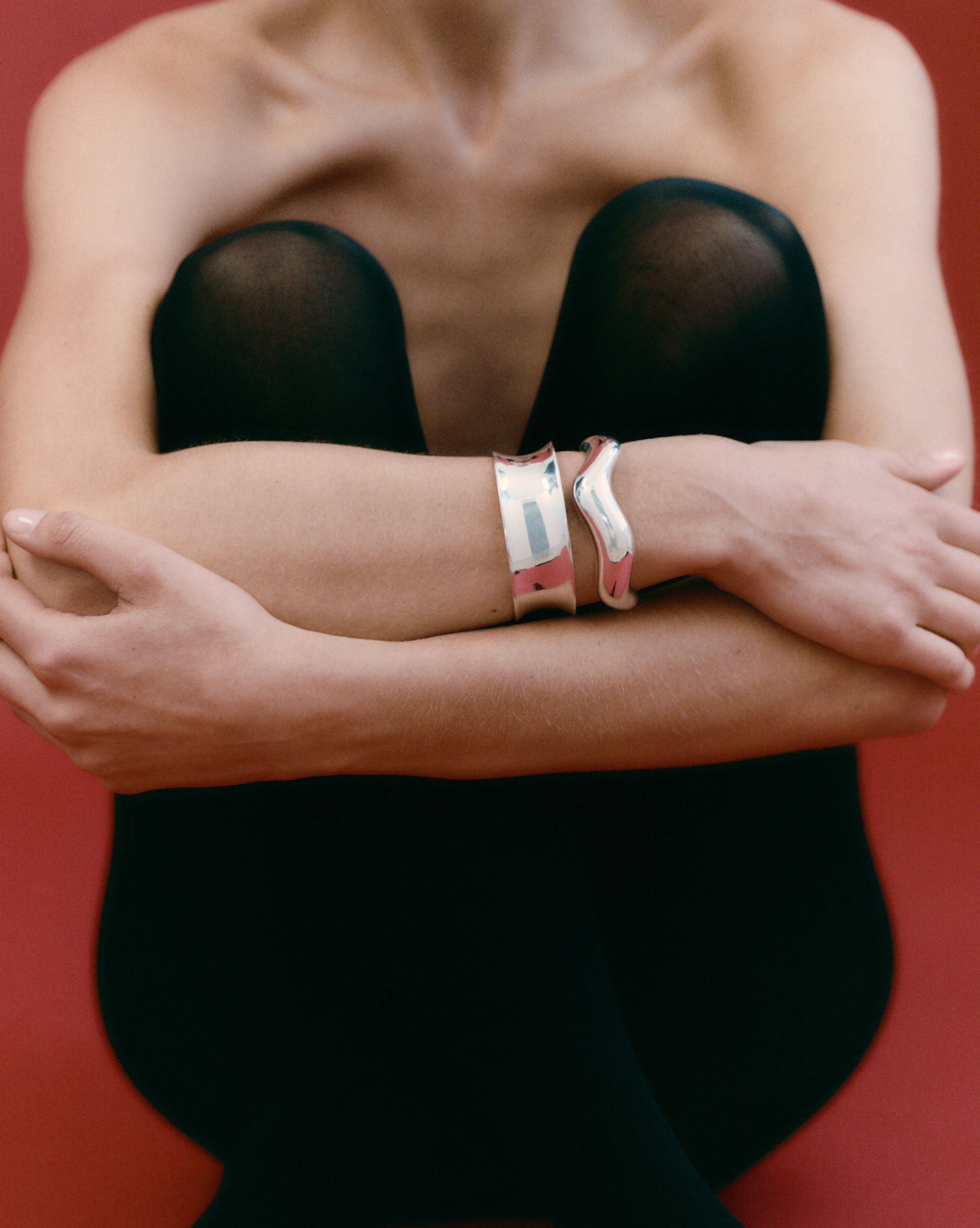 Woman wearing AGMES 0.925 sterling silver sculpted abstract cuff set.