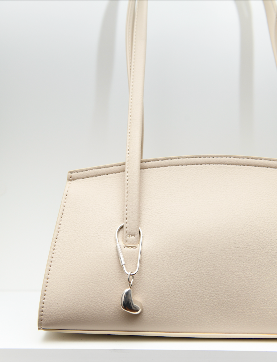 .925 Small Sculpted Heart Keychain on tan bag.