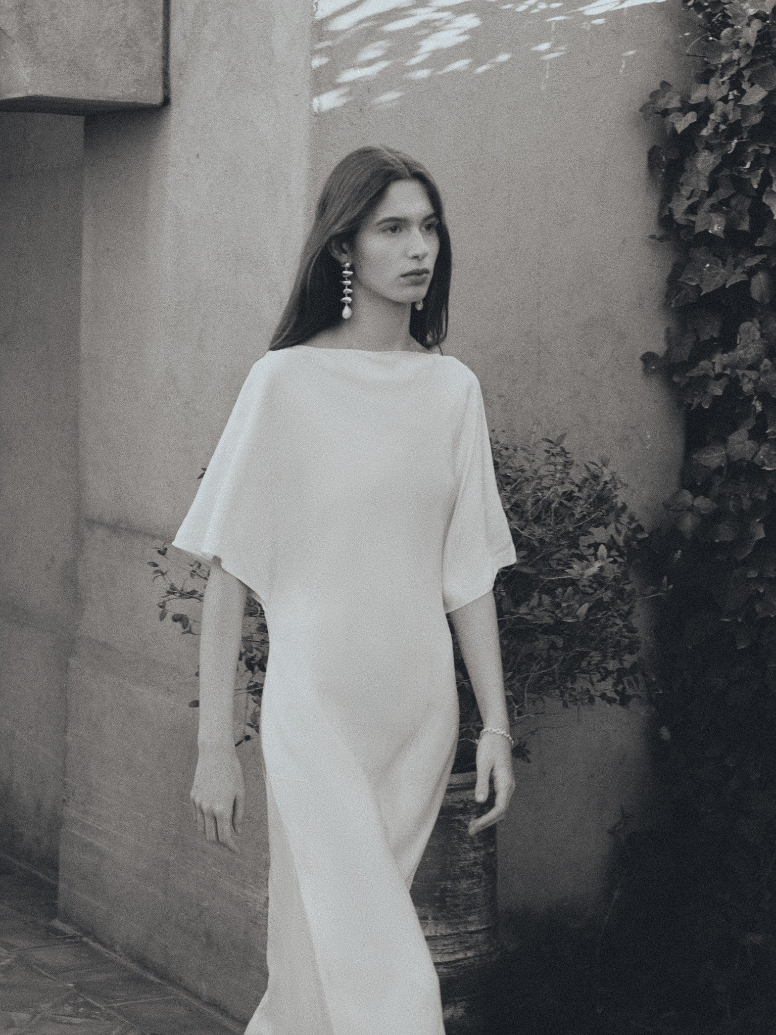 Woman wearing AGMES 0.925 sterling silver long drop pearl Flora earrings.