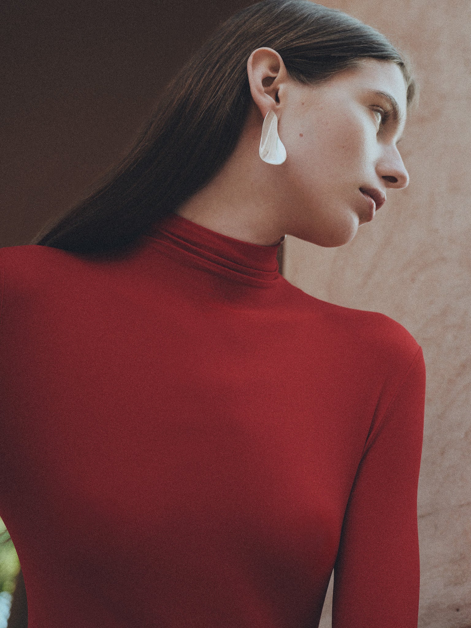 Woman wearing AGMES 0.925 sterling silver long sculpted earrings.