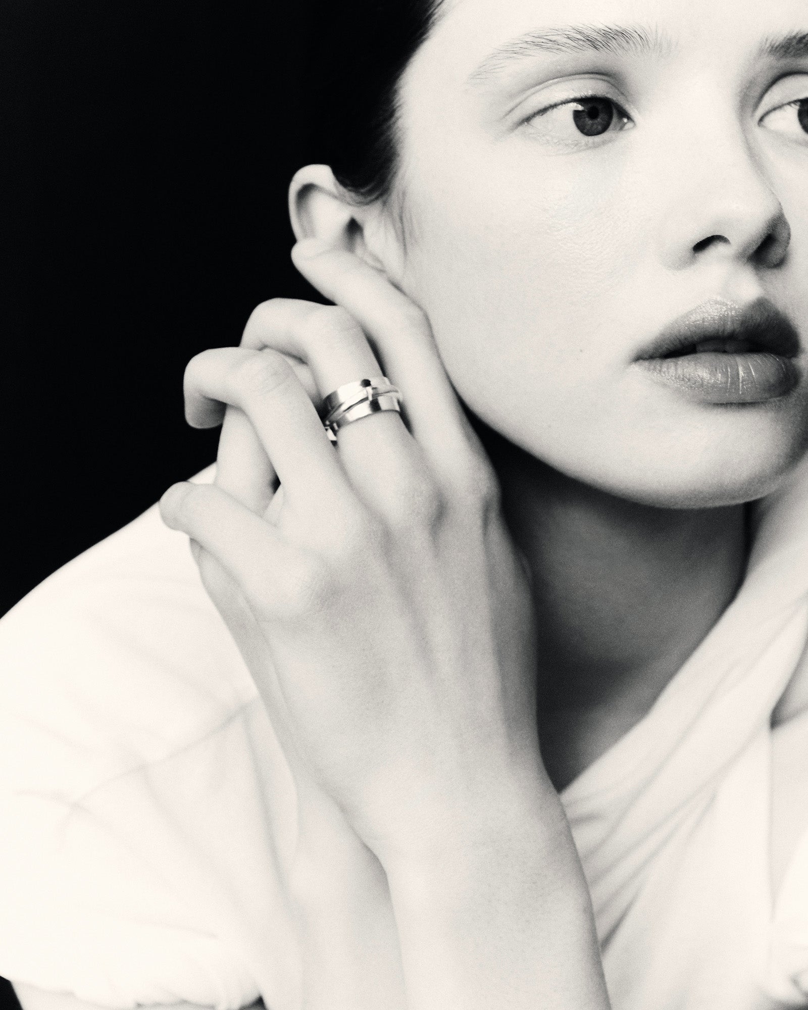 Model wearing AGMES .925 sterling silver Medium Arden Cigar Band Ring on middle finger, black & white