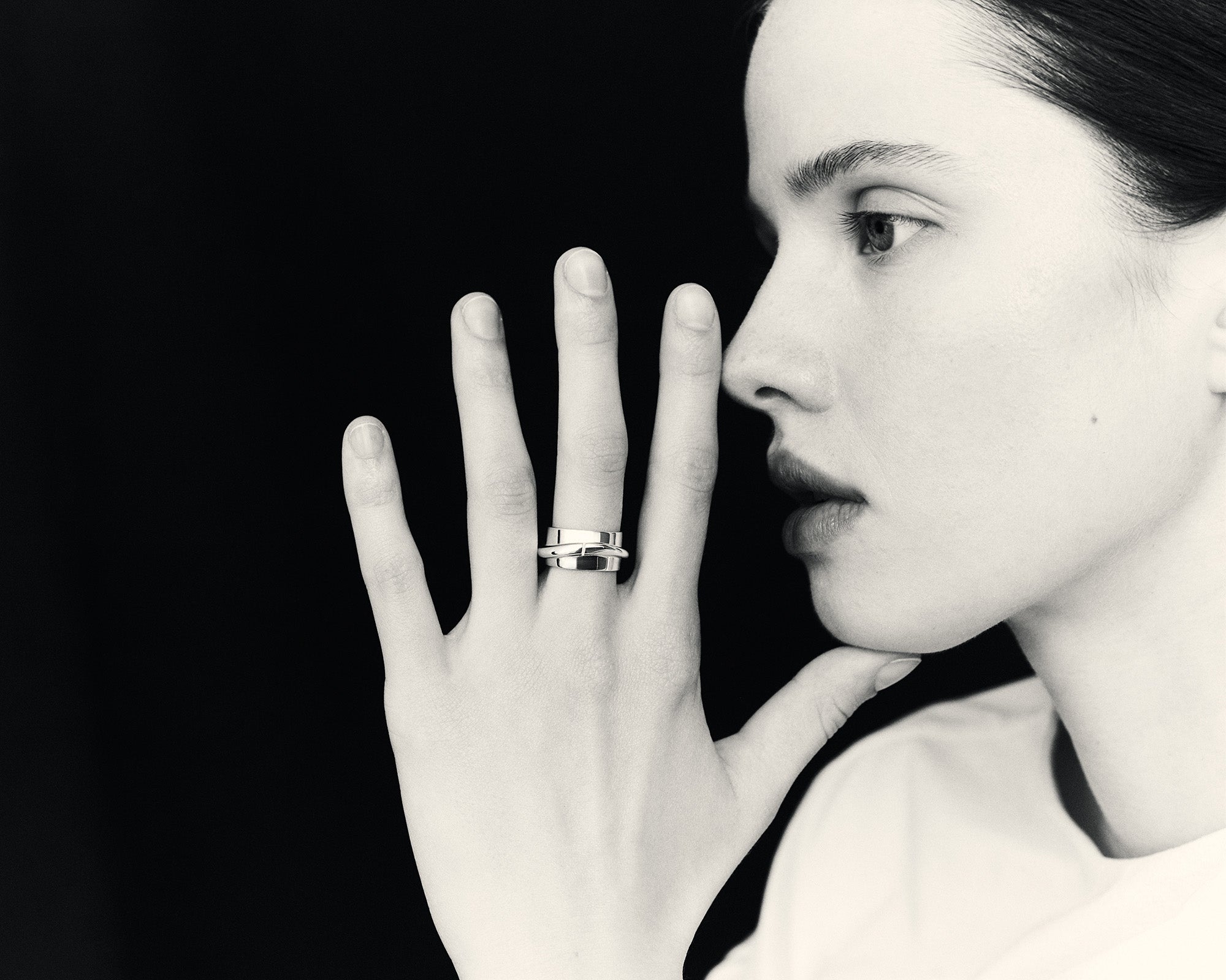Model posing with AGMES .925 sterling silver Medium Arden Cigar Band Ring on middle finger, black & white
