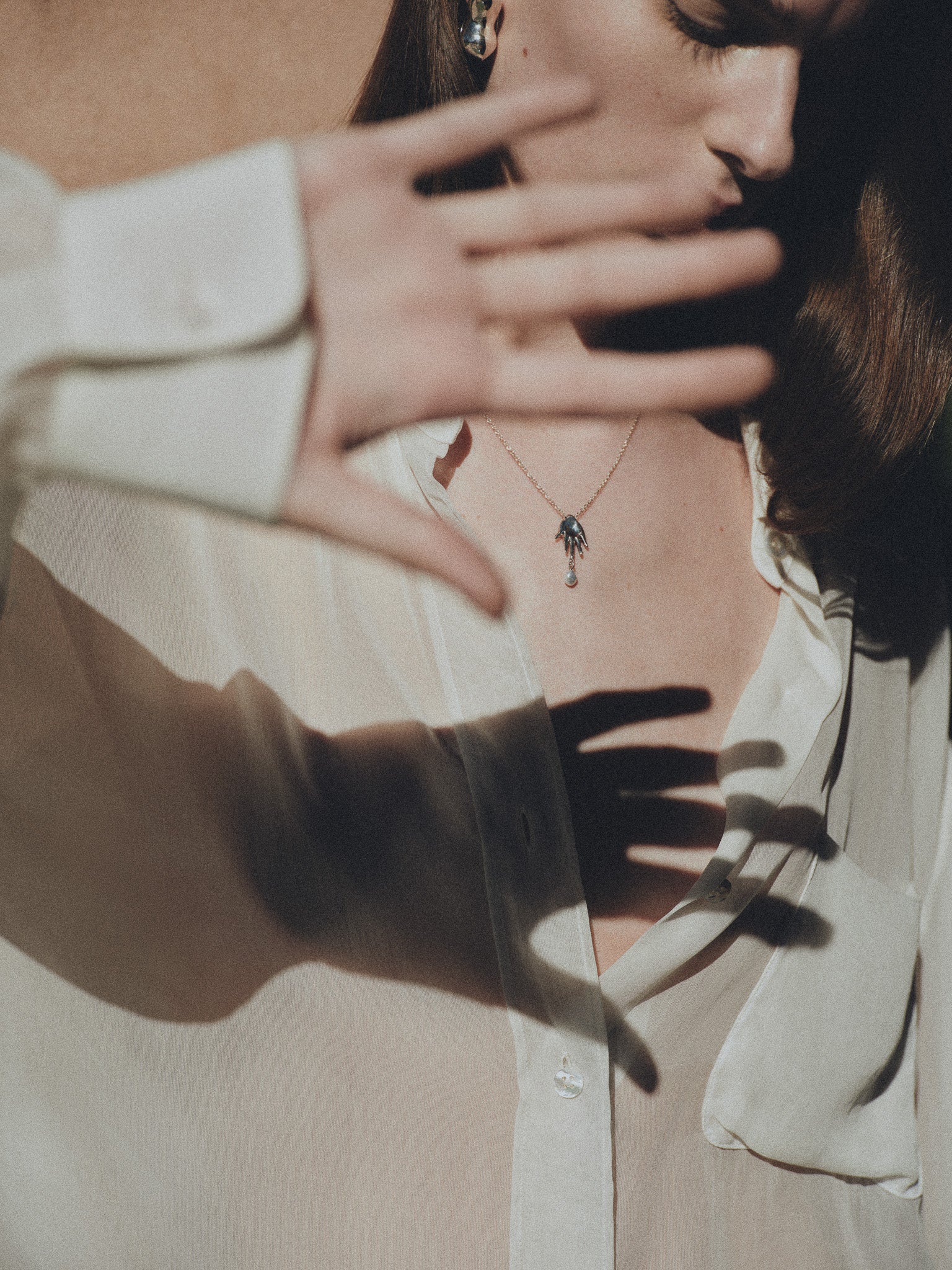 Woman wearing AGMES .925 Sterling Silver mini lee abstract hand pendant with freshwater pearl.