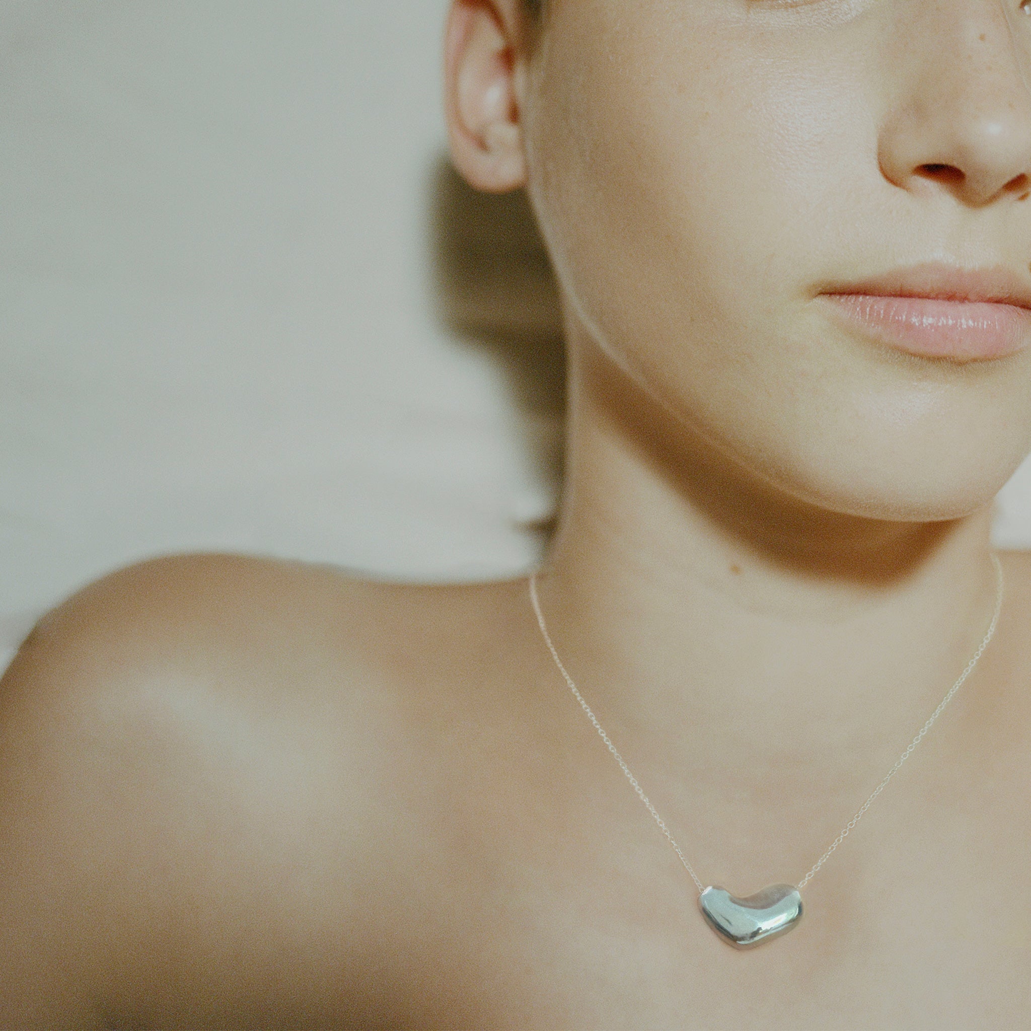 Model wearing AGMES .925 sterling silver Small Sculpted Heart Pendant.