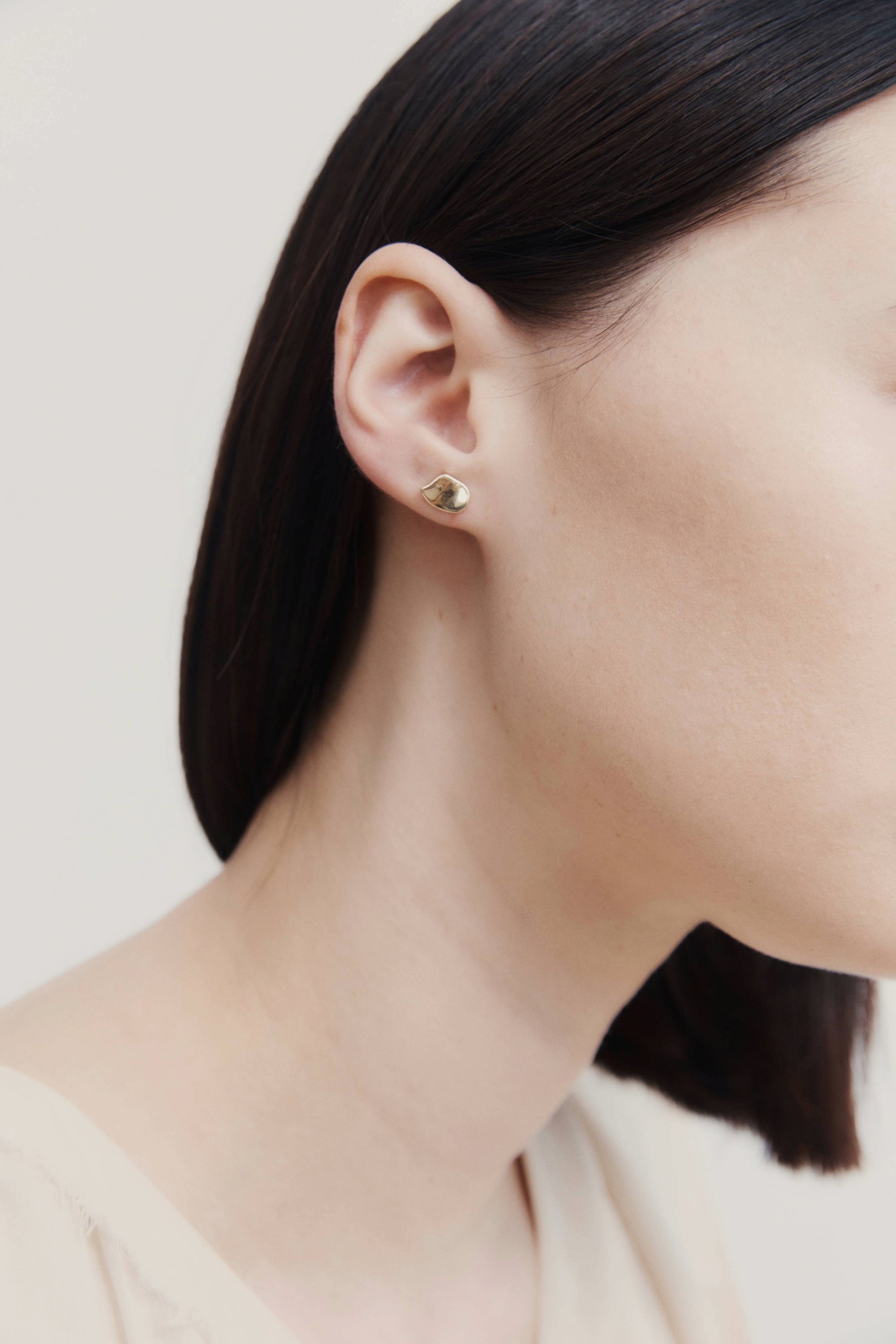 Model wearing sterling silver asymmetrical stud earring