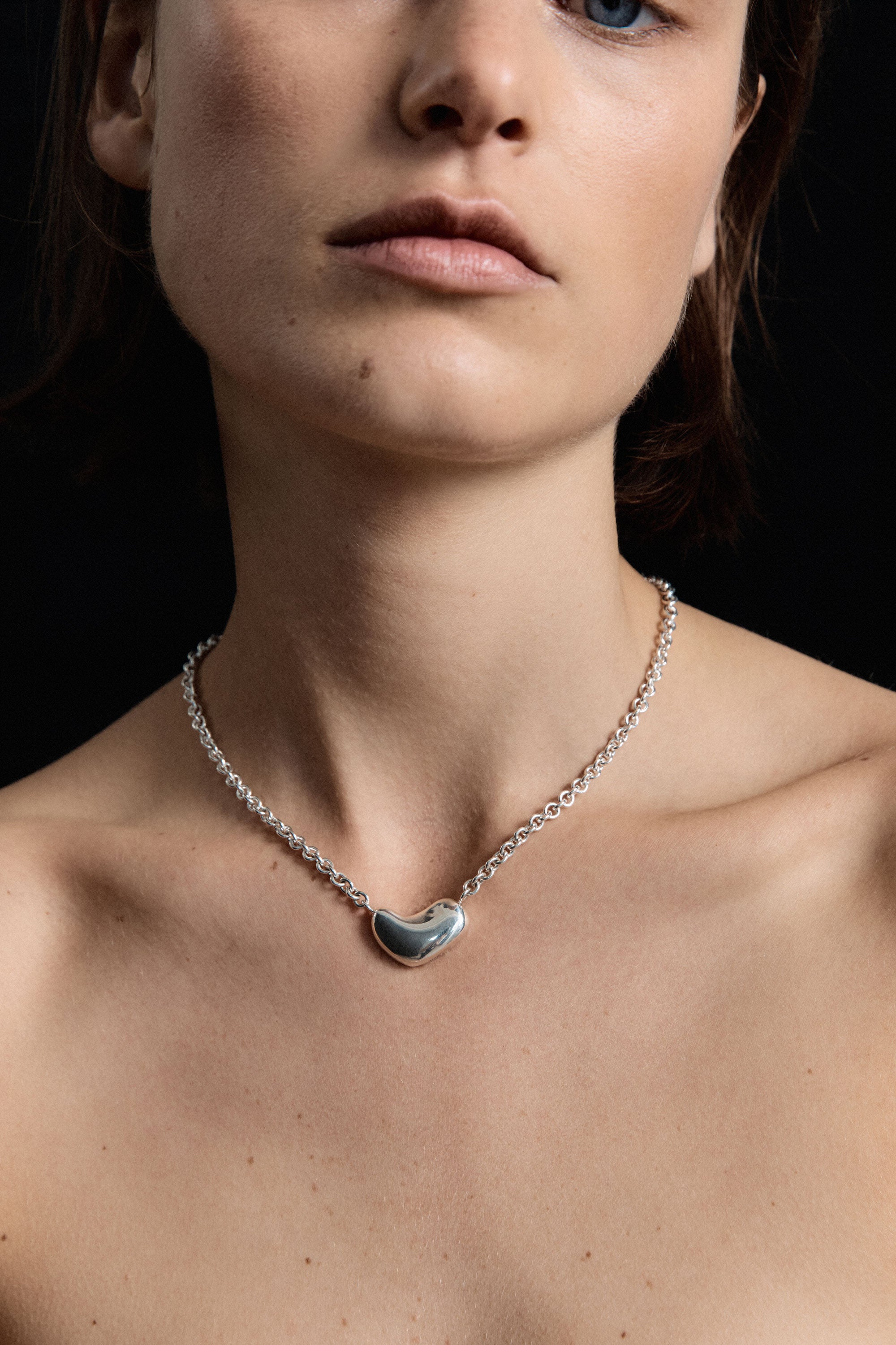 Woman wearing the AGMES .925 Sterling Silver Small Sculpted Heart Pendant II on chain necklace.