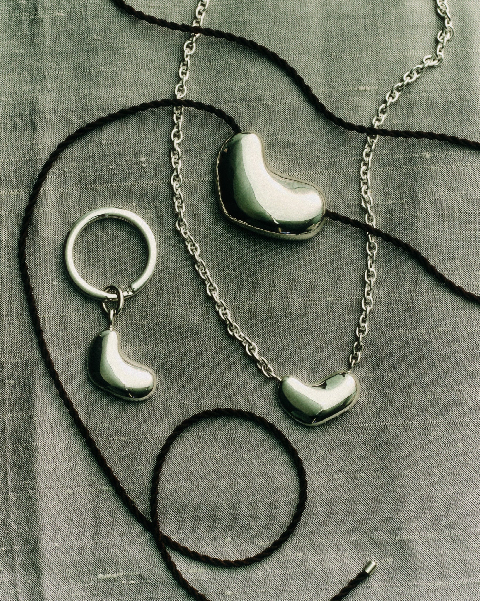 AGMES .925 Sterling Silver Small Sculpted Heart Pendant II, Sculpted Heart Pendant on black suede, and Sculpted Heart Key Chain.