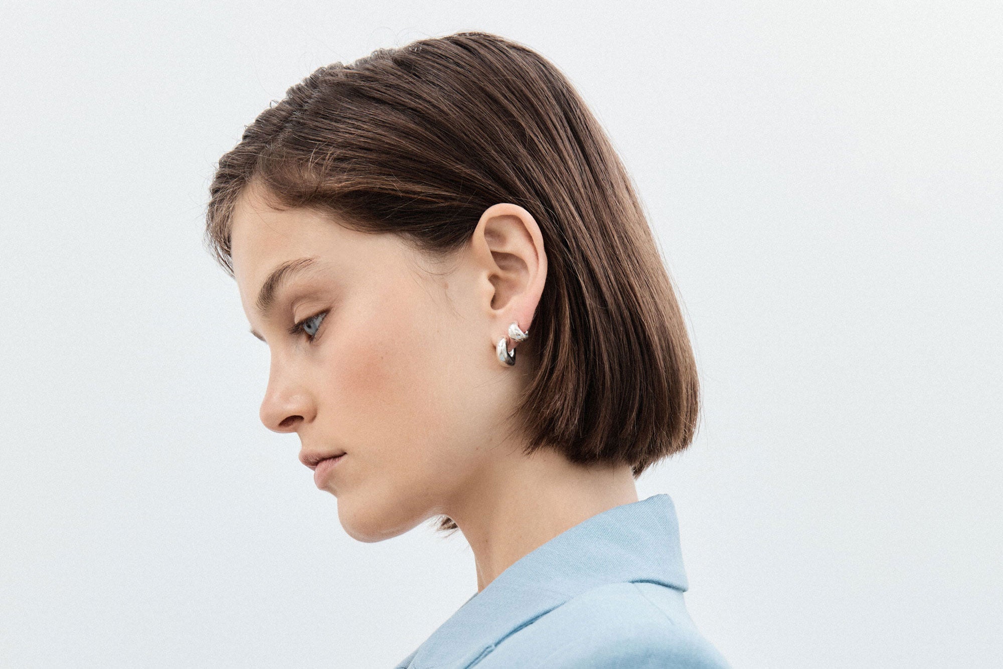 Woman wearing AGMES 0.925 sterling silver small Dahlia hoop earrings set. Huggies