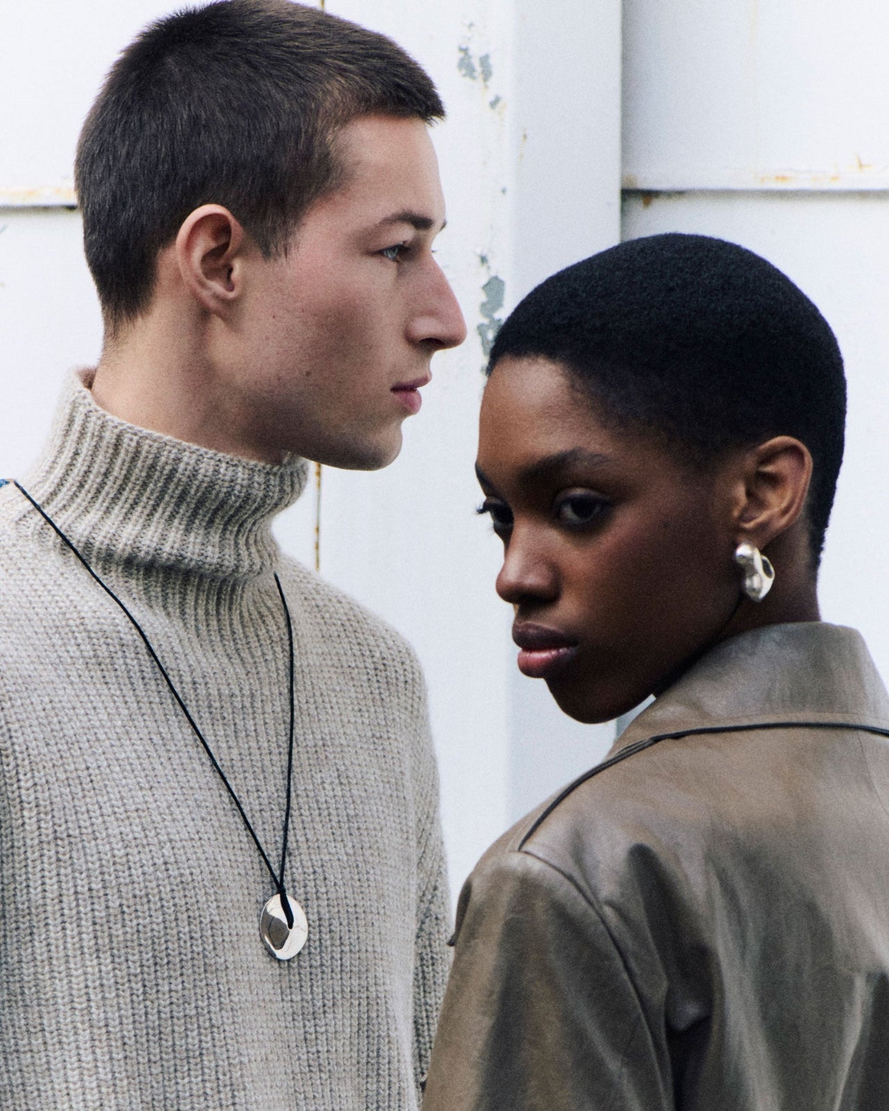 Two models wearing .925 sterling silver AGMES bubble hoops and cora pendant on black suede cord