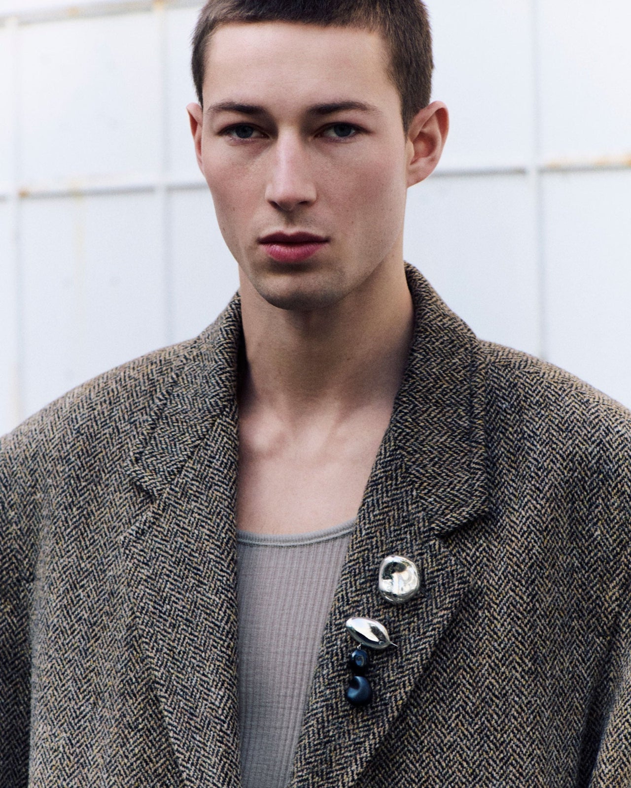 Male model wearing AGMES .925 sterling silver Gia Brooch and Tess Brooch with onyx stone accents