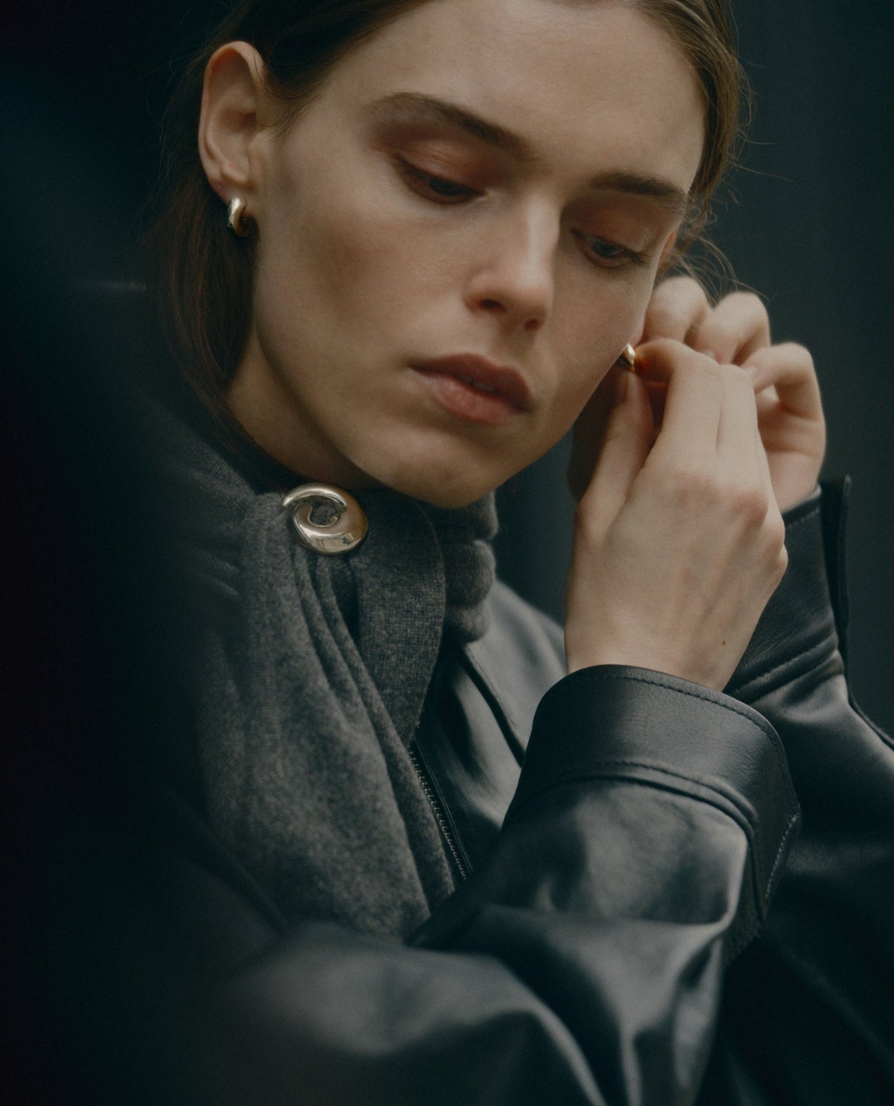 Model putting on .925 sterling silver AGMES small dahlia hoops