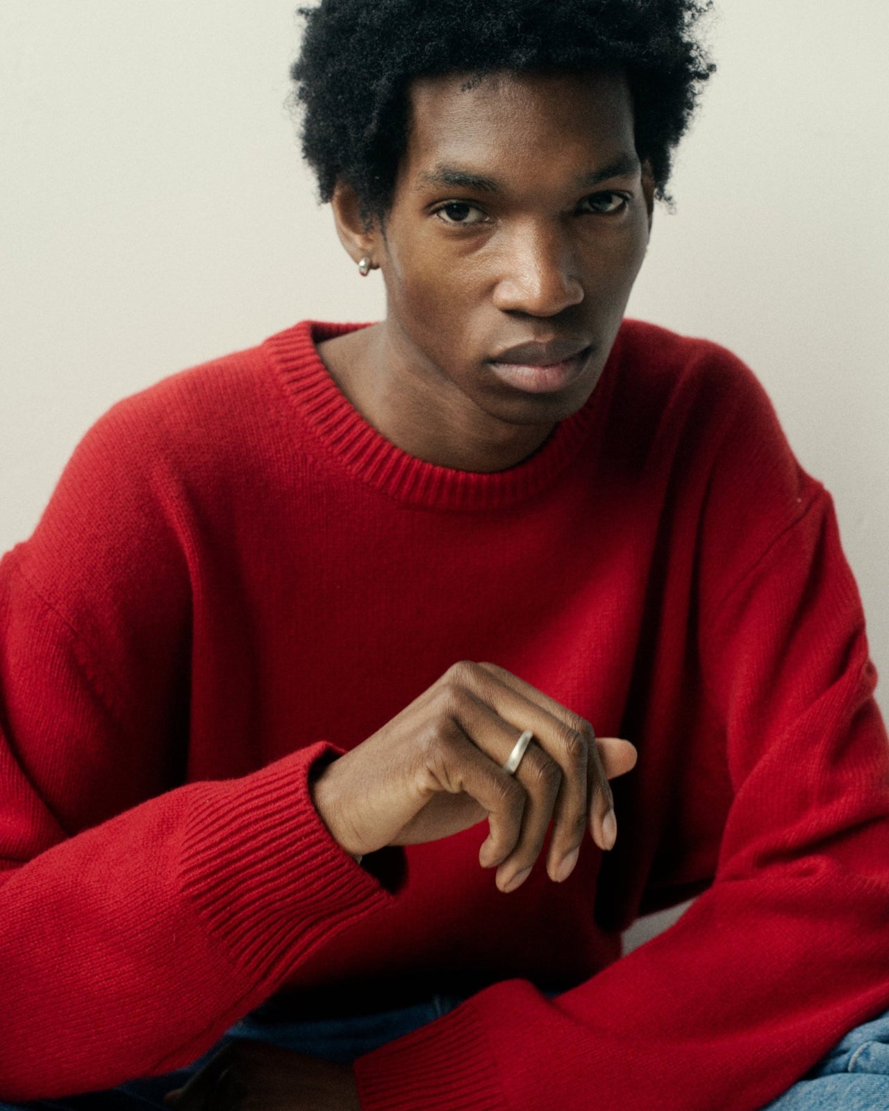 man wearing sterling silver thin domed ring as wedding band in red sweater